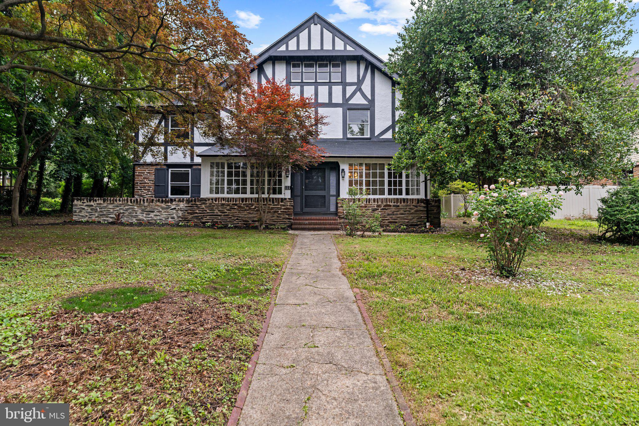 Welcome to 111 Edgehill Rd, a meticulously restored and fully renovated Tudor-style estate offering 7 bedroom and 4,965 square feet of luxurious living space, nestled on a lush and private .63- acre lot. Every inch of this home has been thoughtfully restored, seamlessly blending modern elegance with timeless charm. A stately, sun-drenched sunroom welcomes you into the home, featuring elegant wainscoting ceilings and modern ceiling fans. As you enter, you will be impressed with the gleaming hard wood floors that have been brought back to their original glory. On the right, French doors lead you to the formal dining room, adorned with stunning chandeliers and original stained and leaded glass windows. Across the hall, you will find the elegant living room, where a cozy wood-burning fireplace sets the perfect ambiance for gatherings.
The kitchen, a chef’s dream, is outfitted with a full suite of coordinating GE Café appliances, including a 48” commercial-grade range top, double oven, under the counter microwave, and a built-in beverage cooler. Perfect for entertaining, the kitchen features abundant custom cabinetry, quartz countertops, an eat-in island, wine bar, and pantry closet. Adjacent to the kitchen is the window-lined breakfast room, which offers panoramic views of the lush, landscaped grounds. Step through the rear door onto a patio—perfect for relaxing or entertaining—and enjoy easy access to the expansive backyard beyond. A stylish powder room completes the first floor.
Upstairs, the second floor showcases a luxurious primary suite with custom his-and-hers walk-in closets with ample space for storage and organization. The stunning primary bathroom is a true retreat, featuring elegant marble tile, a walk-in shower, a luxurious soaking tub, and a private water closet with its own door for added comfort and privacy. Two additional bedrooms, a large hallway bath, and a deluxe laundry room complete this level. The third floor adds four more generously sized bedrooms and a beautifully designed full bathroom, ideal for guests or family.
Outside, a detached carriage house sits at the rear of the property, offering a lower level two-car garage, and an upper-level living space that awaits your finishing touches. Whether you envision it as a rental unit, guest house, or in-law suite, this versatile space offers endless potential.
Extensive updates throughout the home include new roof, gutters, and down-spouts on both the main house and the carriage house, 200-amp electrical service and new wiring throughout the main house and carriage house, new dual-zone central A/C and heating, new plumbing, and new windows—ensuring long-term comfort and peace of mind.
Located on a quiet, tree-lined street within the highly desirable Lower-Merion-School-District, and walking distance to houses of worship, restaurants, stores, and just minutes from the train station, this home offers both tranquility and connectivity. Don’t miss this rare opportunity to own a fully updated historic gem —schedule your private tour today and experience it for yourself.