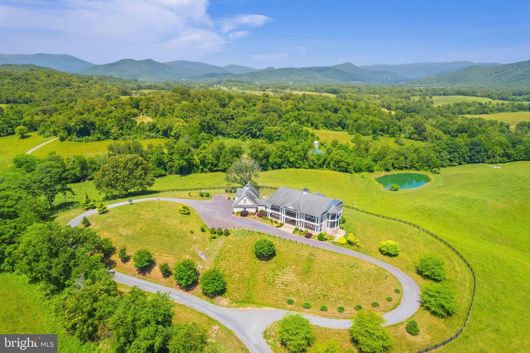 Magnificent perch in the heart of beautiful Rappahannock County. The stunning 360-degree views. The manageable 27 acres. The immaculate 9,000 square feet of elegant living and entertaining space with a whopping 2,500 square feet of balconies and porches. This perfectly situated residence is between Little Washington and Sperryville and lives a full circle view of one of the most beautiful vistas in the Eastern US —the “morning side” of the Blue Ridge Mountains, Shenandoah National Park, and those gorgeous nearby rolling hills, vineyards, and pastures. Rare elevator access to all three finished levels. Each entertaining room and all four main house bedrooms open directly to their own view and outdoor space. The residence was designed to showcase the owners' fondness for art and antiques combined with their love of this extraordinary location overlooking Rappahannock County and the Blue Ridge. Everywhere you turn, a special treat waits. A wide gallery with lighting for the most discerning art collector. Delightful year-round sunroom. Flexible multi-use finished basement, ready for movie night, wine storage, workouts, overflow guest quarters - name it! Impressive, expansive 4-car garage with workshop spaces and above, a nice guest/rental/caretaker 1BR/1BA apartment. You and your guests will love - and live - those unobstructed views from nearly every angle. Near both Little Washington and Sperryville, you are a stone's throw from world-class restaurants, breweries, wineries, and the entry to the National Park. Hummingbird Hill offers a rare combination of space, panorama, privacy, and elegant comfort in one of the loveliest spots we've seen.