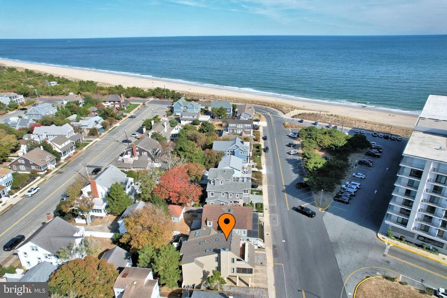 Rare opportunity for large Atlantic Ocean Views along with Lake Gerar Park views from this ocean block classic North Rehoboth Beach home just a few hundred feet from the beach and boardwalk. All the heavy lifting is done, including new windows, new roof and new HVAC.  With a little remodeling or updating this home would be a fabulous beach get-away. First floor features a bedroom with a half- bath/laundry room that could possibly be expanded into the adjoining storage closet. Second floor has two more bedrooms, a full bathroom with skylight, a living room with wood-burning fireplace, custom built-in shelving & two sets of sliding glass doors leading to a covered, full length of house, screened porch with ocean views. The centrally located kitchen opens to a dining area that easily seats 8 with bench storage & peninsula seating. Through Andersen wood french doors, the kitchen leads to a large tiled sun room with floor to ceiling casement windows allowing in tons of natural light. Exit through Andersen sliding glass door to a rear deck perfect for housing a grill and lawn chairs for sunbathing. This second level deck boasts an operational outside elevator lift to the ground level for easy access of heavy objects and /or wheel chair accessibility. The  private third floor is an oversized primary bedroom with full bath and large walk-in closet  along with its own personal deck overlooking waves crashing on the beach! Here you have a beautiful view of paradise including the recently renovated Lake Gerar Playground and a wide view of the Atlantic Ocean. Outdoor features include two outdoor showers, two storage sheds and a storage closet for all the beach essentials, a rear porch (easily screened) on first floor, a rear upper deck, a second floor large covered screened porch and a third floor deck for some of the best orchestra seats in town. Improvements  to this well-cared-for home include new Andersen casement windows, new cedar siding, hot water heater & new fireplace cap. With traditional knotty pine walls, open staircases and coastal furnishings - this property exudes cherished memories. There may be room for a pool since ground coverage has not been maximized.
Another option would be to build your dream beach home and enjoy the rare ocean views from multiple rooms of your brand new home. This property is conveniently located  close to the mile long Rehoboth Beach boardwalk & activities, shopping, playground, lake fishing, bike paths, fine dining and much much more! Rental income for 2024  was over $120,000.00.