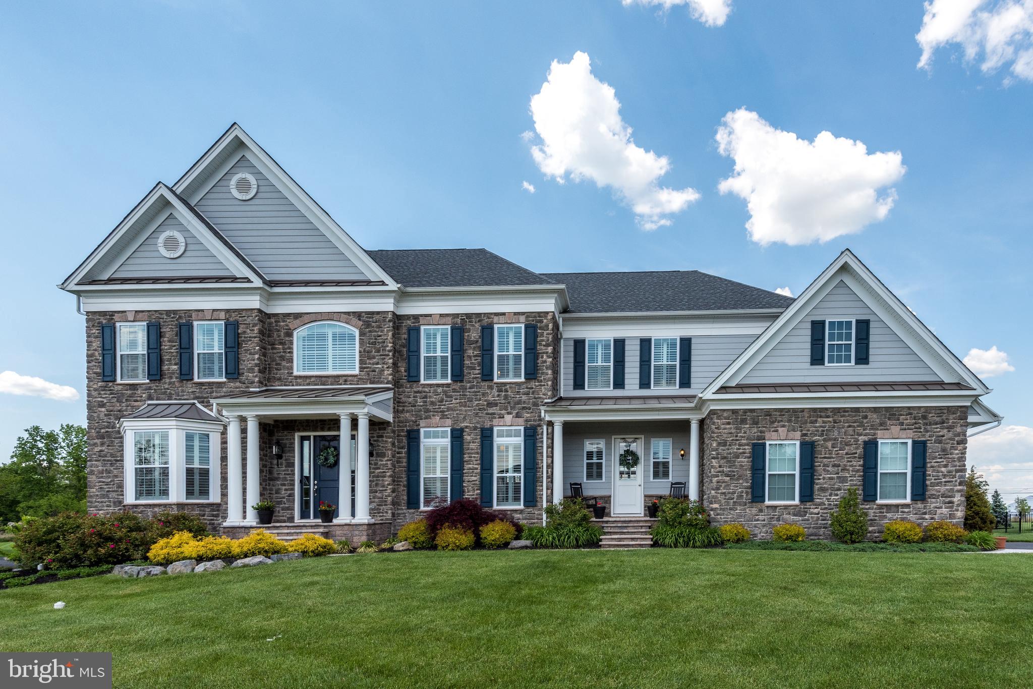 This absolutely stunning home in desirable Estates at Mill Creek Ridge, is only 3 years old and better than new! Experience the relaxing rural feel with views of horse farms while still being conveniently located just 10 minutes from Doylestown, 15 to Newtown and New Hope for your choice of shopping, dining and culture. The stone façade, front porches, columns and double front doors make for exceptional curb appeal. Once inside, you will love the gracious foyer with straight back views of the rear grounds as in the old-style Bucks County Manor houses. So refreshingly different from the traditional colonial! To each side of the foyer are the living and dining rooms showcasing the upgraded trim package throughout. Step through the dining room to the butlers pantry with rows of cabinets & counters to store dinnerware and have dishes and beverages stand ready for serving. Around the corner is the heart of the home encompassing the amazing gourmet kitchen, eating area and family room. With the walls of windows, the open space is light and bright even on the cloudiest of days. The gourmet kitchen is the place to create while entertaining family & friends seated at the counter. And the creating is easy with the upgraded Jenn-Air appliances and 6 burner stove with double ovens plus wall ovens! Have to do some work? There is a wonderful computer room adjoining the kitchen – perfect for managing the bills or homework for the kids. Working from home today? Tucked away in the rear corner of the house is a lovely, peaceful office with beautiful back yard views. Choose the main staircase or the rear stairs off the kitchen to access the second level. The elegant main suite has a lovely sitting area, luxurious bathroom with freestanding soaking tub, frameless shower, makeup vanity and private commode. The walk-in closet has a large packing island! All three spacious additional bedrooms feature private bathrooms and walk-in closets. A convenient laundry room completes the second floor. Gather for relaxing fun in the finished walk-up lower level which features a wet bar, TV area, bedroom/playroom/office space, full bath and exercise area. Exit to the wide-open, fully fenced back yard with a wonderful playset and in-ground trampoline! Don’t miss your opportunity to see this fabulous home – make your showing appointment today!