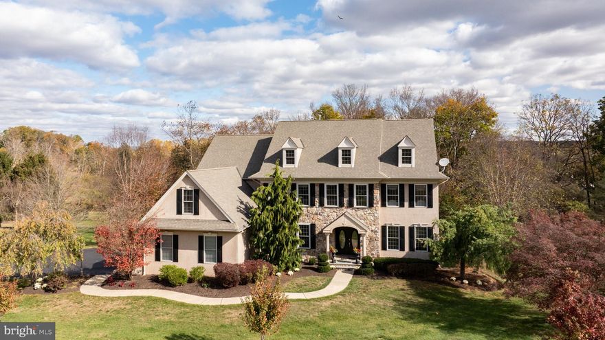 Tucked away on a quiet cul-de-sac in the desirable Rolling Hills community, this elegant light-filled 4,638 sf home embodies graceful country sophistication with a modern sensibility. Surrounded by 2.44 acres of lush landscaping, open lawn and light woods, this executive-style residence offers privacy, tranquility, and a quintessential Bucks County setting—complete with views of the historic Erwinna covered bridge.
Inside, the home’s traditional design shines through lofty 9’ ceilings, rich oak floors, and extensive millwork. The large and welcoming greeting room foyer opens to formal living and dining rooms, while the chef’s kitchen—featuring granite countertops, newer stainless appliances, and a walk-in pantry—flows seamlessly into the breakfast room and family room with its vaulted ceiling, floor-to-ceiling stone fireplace, and Palladian window. French doors open to a spacious Trex deck and the lower, expansive paver terrace overlooking the wooded backyard, creating an ideal setting for entertaining.
A private study with French doors to its private Trex deck offers the perfect home office or studio. Upstairs, the primary suite includes a sitting-dressing room, enormous walk-in closet with boutique-style built-ins, and the spa-like bath with separate vanities, whirlpool tub and walk-in glass shower. Three additional bedrooms—one en suite—feature generous closets and natural light.
The unfinished lower level with 9-foot ceilings and plumbing for a future bath offers endless possibilities for expansion. Additional features include a NEW ROOF, large 3-car garage, stand-by generator, sound system throughout, efficient propane heat and hot water, high-speed well pump, and radon mitigation system. Recently refreshed with new paint, newer heat/AC zone, and septic pump, this home offers the perfect blend of polish, comfort, and well-maintained house systems for peace of mind.
Ideally located amidst miles of walking trails, the Delaware River and Canal State Park, and mere minutes from Frenchtown and New Hope, this home is a peaceful retreat that remains perfectly connected just 90 minutes to NYC, 75 to Philadelphia. Come experience refined country living in Tinicum Township.
