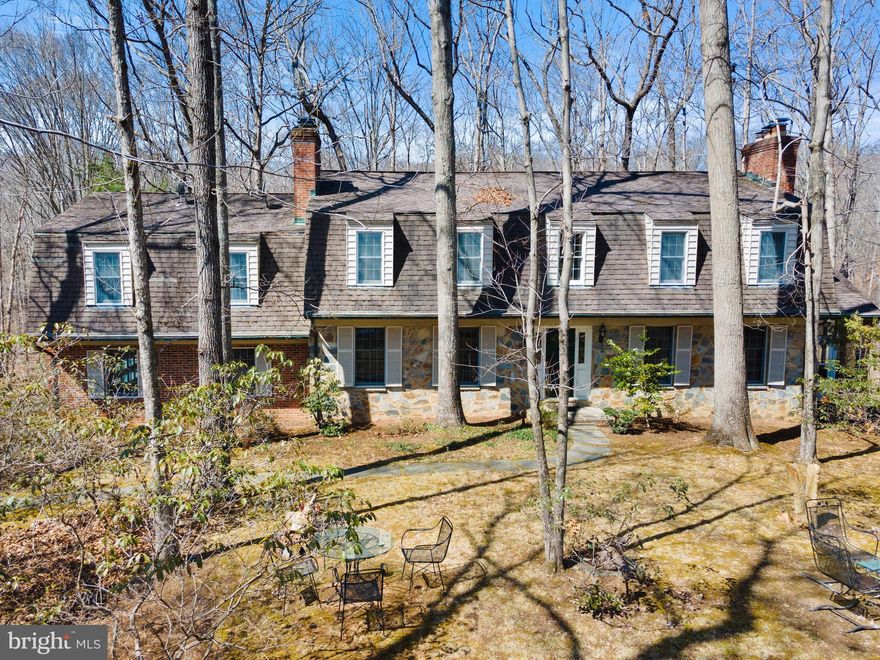 We are proud to present you with this awesome Clifton Retreat!  Nestled in the woods on 5.34-acre lot, this impressive large colonial offers unsurpassed privacy and your own little bit of history.  The stone fireplace in the charming family room/main level bedroom comes with hand-hewn beams from a 1730 New England Inn, visited by George Washington. This extraordinary and unique estate property boasts five bedrooms and four baths on three finished levels with nearly 5,000 square feet of living space located within minutes from the sought-after town of Clifton.  Located on a large 5.34-acre lot provides everything one can dream of with no HOA.  Magnificent view of the Johnny Moore Creek!  The inviting living room features golden-oak hardwood flooring, sunlit windows and colonial crown moldings.  Stay warm with the amazing floor-to-ceiling brick fireplace with woodstove insert.  A traditional dining room boasting beautiful hardwood flooring, recessed lighting, crown molding and chair railing.  Step out onto the screened porch with built-in grill and ceiling fan.   Enjoy the spacious updated kitchen featuring granite countertops and lots of cabinet space, leading you into the mini kitchen with double walk-in pantries and fully remodeled marble tiled bathroom.   There are a total of 7 fireplaces, five bedrooms, a large kitchen, two walk-in pantry closets, mudroom with mini kitchenette, four full baths, closets galore and side-load two car garage.  An out of the world sunroom at the back overlooks the private paradise that lays beyond!  The detached 1300 SF building/garage is a dream comes true to a small contractor or hobbyist.  Currently being used as an Art Studio with lots of natural lighting.  The building can be used as a garage, workshop or used for a variety of hobbies!  The space provides both heat/AC, wood fireplace and a separate work room/office.  This awesome building features around 1300 square feet of space.    The gorgeous fully finished lower level features a large rec room with soundproof walls for the musician in the family!  A great entertainment space with full wet bar, a large wine cellar room, and full bathroom with a steam sauna.  Step out on the large half covered patio for family gatherings!