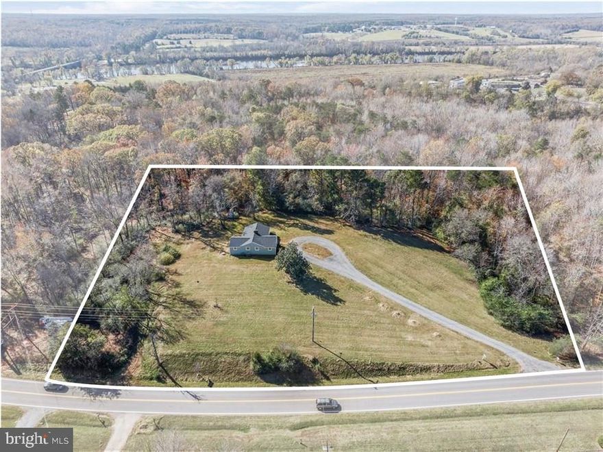 Welcome to 2801 River Road West where you will find a carefully RENOVATED and PERMITTED 4 bed, 2 full bath, 2,115 square foot, Ranch-style home on 4 ACRES of privacy in Goochland County! As you enter the home you are greeted by FRESH PAINT throughout the entire home, a coat closet in the foyer, and beautiful refinished hardwood floors throughout. To your right is the naturally lit living room from the triple windows, recessed lighting, a new modern-style ceiling fan, brick wood burning fireplace with mantle and built-in shelving with a bar area, and crown moulding. Next is the dining room with a new chandelier and chair rail moulding and is open to the kitchen that features a large island with room for bar seating, MARBLE countertops, recessed lighting, stainless appliances and stove hood, tile backsplash, NEW White Shaker cabinetry with crown moulding, basement access and access to the spacious back deck. There are 3 spacious secondary bedrooms that all have large closets, new modern lighted ceiling fans, and a conveniently located full hall bathroom that has been completely updated with new vanity, new mirror/light fixtures, tub and shower combo with tub to ceiling tile, new tile flooring, and a linen closet. Rounding out the 1st floor is the Primary bedroom suite that features recessed lighting, a large closet, and an impressive en-suite bathroom that has a glass door shower, floor to ceiling tile, new vanity, new tile flooring, and new fixtures/mirror. Heading down to the basement, you are met with new Luxury vinyl plank flooring, a white brick wood burning fireplace w/ mantle, and a HUGE rec room/family room. Finally there is the laundry room with a washer & dryer, and a basement workshop/storage area. Welcome home!