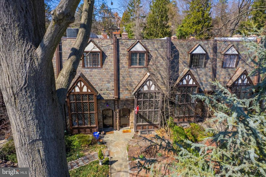 Welcome to this distinctive 4-bedroom, 3-bath Tudor-style townhome located on a picturesque, tree-lined street in the desirable East Falls section of Philadelphia. This home effortlessly blends historic charm with modern conveniences, offering the perfect balance of character and comfort.

As you approach, you’ll be greeted by the original solid wood front door and stunning leaded glass windows. Step inside to find beautiful hardwood flooring throughout and a spacious living room featuring a dramatic 2-story cathedral ceiling with exposed wood beams and a cozy nook with a fireplace—perfect for relaxing evenings.

The formal dining room flows into the modern kitchen, equipped with stainless steel appliances and rich cherry cabinets, ideal for any home chef. Adjacent to the kitchen is a versatile family/bonus room, currently used as a craft studio, along with a full, updated bathroom completing the main level.

The second level offers even more charm with built-in bookcases and a cozy reading nook overlooking the living room below. The owner’s suite features an en-suite bathroom and French-style doors leading to a spacious, covered deck with views of the separate rear bonus yard—perfect for morning coffee or evening relaxation.

On the upper level, you’ll find three additional generously sized bedrooms and a vintage black-and-white tiled bathroom that adds to the home’s timeless appeal.

Outside, off-street parking is available at the rear, and across the alley, you’ll discover a delightful patio for outdoor dining. The upwardly sloping garden is a gardener’s dream, with compost-amended soil ready to yield raspberries, asparagus, squash, artichokes, and more!

Enjoy the perks of city living with Fairmount Park just steps away and the vibrant nightlife of Main Street Manayunk only minutes from your door. You’ll also be close to movies, fine dining, riverfront restaurants, and boutique shops. Commuting is a breeze with easy access to Kelly Drive, East Falls Bridge, Martin Luther King Drive, and SEPTA’s East Falls Train Station.

Don’t miss your chance to own this one-of-a-kind home that offers historic charm, modern amenities, and an unbeatable location!