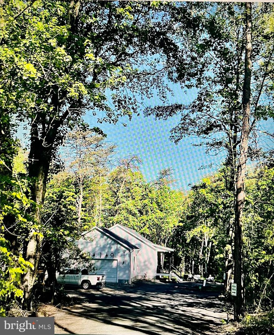 Location, location, location! Just a few minutes from Ft. Meade and NSA; Maryland routes 295, 95, 32, and 100. Close to Arundel Preserve, Columbia, BWI airport, and Jessup park is a .5 mile away. Calling all nature and project lovers, and/or those who are homestead dreaming! 3-year-old modular home (known for their solid construction) enveloped with tree coverage and conservation acreage. This is a gorgeous .92 acre lot with house located 300' off of the main road, offering one of the most private lots in the area for its size. It is homestead-ready with a new Amish-built mini barn and shed, two black chain link fenced areas (we had chickens and goats on one side, dogs on the other) with latch gate connecting the two, inviting front porch and a large partially screened back deck with high-end Jetsetter LX salt-system hot tub. Finished basement, approx 1500 on main (2bed, 2bath) and 1500 on lower (1bed, 1bath). Main Level: double-sided (primary suite & LR) propane fireplace, plantation shutters throughout, gorgeous antique-style large blade ceiling fan in master, ceiling fans (office, L/R, and 2nd bedroom), box ceiling in master, sliding glass doors off of master offer beautiful view of trees and walkout access to hot tub, artisan clay tiles in kitchen, quartz kitchen countertops and copper sink, french glass doors for office (perhaps use as extra bedroom or dining room), two separate vanities/sinks in master, large shower with clay tiles, large walk in closet attached/behind master shower, 2nd bathroom has tub/shower, laundry room with sink, open kitchen and L/R area with high counter bar with dark copper L-brackets, huge garage. Basement: a separate front door, perfect for an additional dwelling, home gym/exercise space, and/or a home business. Lower was used as dance studio space and massage room, has floating floor and mirrors along two of the longest walls, and installed curtain tracks to divide areas if desired. Brass sink vanity in bathroom, copper shower basin, clay floor tiles, plenty of closet/storage space. Exterior: drink your morning coffee/tea and watch deer from the front porch as they cross the 300' gravel driveway and opposite side of the property, lots of guest parking, circle drive option around biogarden, black gutters and downspouts, 50 amp installed for RV and septic drop, lavender garden, fig tree, two weeping willows, yews, berry vines and bushes, butterfly garden that brings in annual monarchs, bat house and family of bats that are pure joy to watch circle the property as the sun sets, extra large hostas, small veg garden, compost area, etc.,..and there is lot of empty space to work with to make it your own oasis. Serious interest only, and must be able to pay the difference, out of pocket, between appraisal and purchase price which might be approximately 50-75K given there are not many comps for this very unique lot and home design. Home sold as is because we are taking a huge loss already. Asking price is our exact combined purchase price for home and land. more photos and a video to come