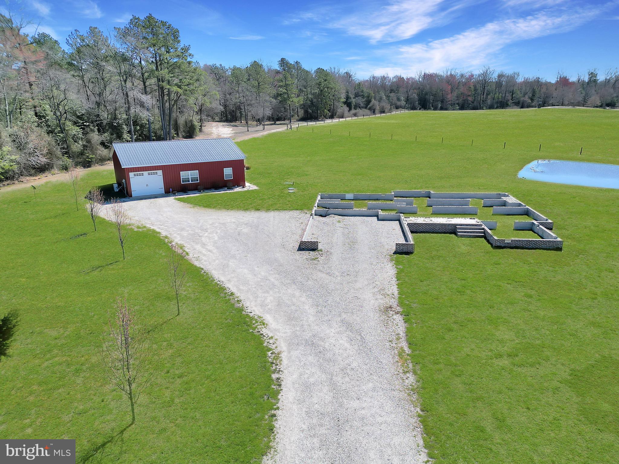 Welcome to this unique 1-bedroom, 1-bathroom pole barn home that offers a cozy, open-concept living space. The well-equipped kitchen features a gas stove, fridge, and sink, perfect for preparing meals. Mini-split units throughout ensure comfort year-round. The spacious living room flows into the master bedroom, which includes a full bathroom with a beautiful tile shower and a closet for added convenience. The property also includes an oversized 1- car garage and extra storage space for all your needs. Enjoy the outdoors from the covered front porch, a great place to relax. The pond is full of wildlife, geese, bass, crappy, bluegill, and much more. On the property the foundation is set for a 1,887 sqft home to be built by the new potential buyer, with a separate septic system already in place. Plans are in place to expand this property to include 3 bedrooms and 2 bathrooms. The 1.5-car garage offers additional space, with an unfinished area above that presents endless possibilities for customization. This property is the perfect blend of functionality, charm, and future potential.