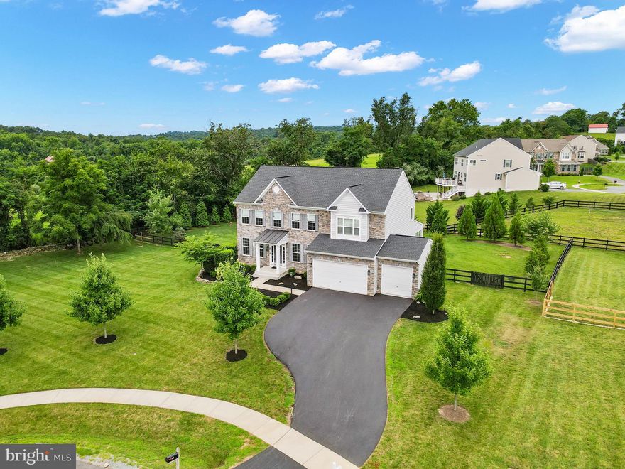 Welcome Home to the highly desired neighborhood of Lake Ridge Estates in Round Hill, VA! This stunning home is situated on a premium .76 acre lot at the end of a cul de sac with seasonal views of Sleeter Lake. A Delaware Model by K. Hovnanian Homes features a modern design, functional layout, and high-end finishes. Wow your guests with the stunning stone exterior elevation on the front of the home, large fenced in yard with tons of privacy, extended driveway and three car garage.  Upon entrance, the formal living room to your left and dining room to your right are perfect spaces for intimate gatherings with friends, holiday meals with family, or space for down time alone. Both rooms offer 4-inch crown moldings plus shadow boxes and designer light fixtures in the dining room and foyer. The two-story family room brings in an abundance of natural light where everyone can be together around the gas fireplace on movie night. The open floorplan allows for the family room to become one with the huge kitchen and breakfast room. At the center of the gourmet kitchen is an expansive island.  The kitchen offers ample countertop space, a 5 burner cook top, double ovens, large pantry, pendant lighting, subway tile back splash and stainless-steel appliances that any chef would love to work with. Since there is always work and learning to be done, you’ll appreciate the private home office that is separate from the living area. Upstairs the owner's bedroom suite features plantation shutters, wood floors that extend through the upstairs hallway and a spacious walk-in closet. Unwind and relax at the end of the day in the spa-like bathroom with a soaking tub, separate shower and double sink vanity. There are 3 additional bedrooms on the upper level which share a full bathroom with a double vanity. The laundry is also conveniently located on this level. The finished basement provides additional living space with the large recreation room with a built-in entertainment piece, a wet bar, 2 multipurpose rooms, and ample storage space. If stunning outdoor living spaces are part of your dream, this is the home for you. Escape the sun or relax and watch the rain from your covered deck. Spend evenings telling stories around the built-in stone firepit flanked by a flagstone patio which is surrounded by the flat fenced in backyard. This home offers so many attractive upgrades such as: Electric vehicle charger, electronic dampers on the HVAC, Dual A/C zones with Nest thermostats for both, water softener, WiFi garage compatibility, beautiful accent walls, built-ins, plantation shutters, premium moldings, decorator’s paint, and outdoor sprinkler systems. As people drive down Harry Byrd Highway (Rt. 7) going west towards Winchester or east towards Leesburg, few know that just beyond the tree line is a secret treasure tucked away between a lake and the mountains: the Town of Round Hill. Round Hill is a charming historic town that is surrounded by Loudoun County farmland and modern neighborhoods. Round Hill is an oasis from the hustle and bustle of city life. Residents take pride in their homes and love to share their hometown spirit with neighbors and visitors. Round Hill is a great place to live and raise a family in the quiet suburbs of western Loudoun County. Residents enjoy living in a gateway to fun and adventure because it is centrally located to numerous outdoor activities such as hiking, kayaking, golfing and more