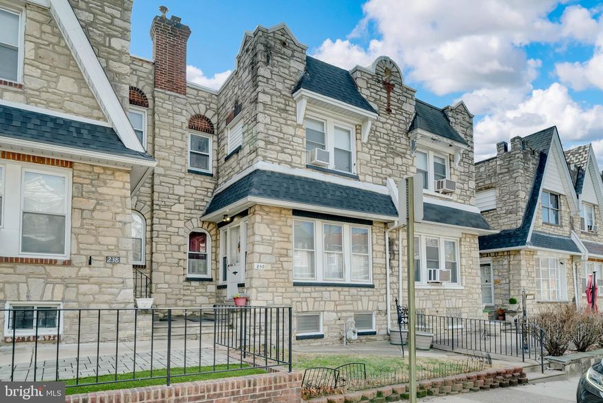 Welcome to this lovely spacious, well maintained 3 bedroom, 2 bathroom stone and brick row home in the Bywood section of Upper Darby.  This home has beautiful hardwood floors throughout the first and second floors.  Upon entering, you’ll find a cozy sitting room that leads directly into the living with a fireplace and high ceilings.  A spacious dining room and kitchen with a private deck complete this floor.  Upstairs is the primary bedroom with attached bathroom that has a single sink and vanity for extra storage and a tile shower.  There are two additional bedrooms and a large hall bathroom with a pedestal sink, a tub-shower combination, and tile floor.  All three bedrooms have hardwood floors that add warmth and original charm throughout.  
The lower level is currently used as storage but has the potential for additional living space for a home office, gym, or playroom.  The laundry is located on this level, as well as a small powder room.  Additional highlights includes a one-car garage, a private driveway for additional parking, and a walk-out basement.  This home is walking distance to 69th Street public transportation and shopping areas.  Don’t miss the opportunity to make this charming home your own!
