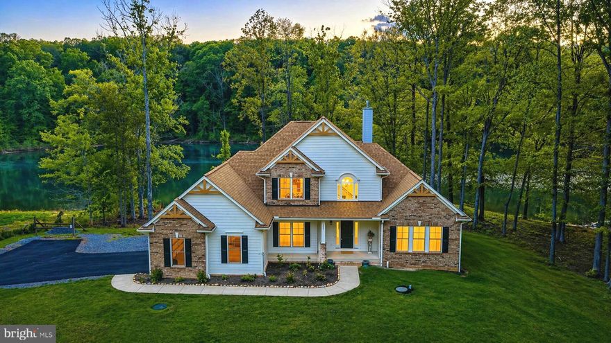 Perched along 125 feet of shoreline in the sought-after Noah’s Landing community on the private side of Lake Anna, this fully furnished, turn-key waterfront retreat offers an effortless entry into lake living. Built in 2023 and thoughtfully positioned on a .95-acre lot, the home captures peaceful water views from a deep-water cove ideal for swimming, floating, and enjoying long summer days. Whether you’re seeking a personal escape or an investment opportunity, short-term rentals are permitted—making this property as versatile as it is inviting. Inside, an open-concept design is enhanced by 9-foot ceilings, engineered hardwood flooring, and a dramatic wall of windows that frame the lake. The family room features soaring ceilings and a gas fireplace with blower and battery backup, creating a comfortable gathering space year-round. The kitchen is both functional and refined with granite countertops, stainless steel appliances, white cabinetry, and a bright breakfast area. A main-level primary suite offers lake views and has a soaking tub, double vanity, and walk-in closet, while an additional bedroom, half bath, and laundry complete the main floor. Upstairs, two more bedrooms and a full bath provide ample space for guests. Outdoor living is just as compelling, with a reinforced composite deck designed for a future hot tub and uninterrupted views of the water. Hardiplank siding with brick accents, a paved driveway, and a two-car attached garage with an EV charger add to the home’s appeal, while features like zoned HVAC, two 50-gallon water heaters, a reverse osmosis filtration system, and an interior access walk-in conditioned crawlspace/cellar reflect thoughtful construction. Offered fully furnished—including kayaks and garage essentials—this property is ready to be enjoyed from day one. Conveniently located near local favorites like El Gran Patron and Pleasants Landing marina, it’s a refined yet relaxed setting to experience the very best of Lake Anna.