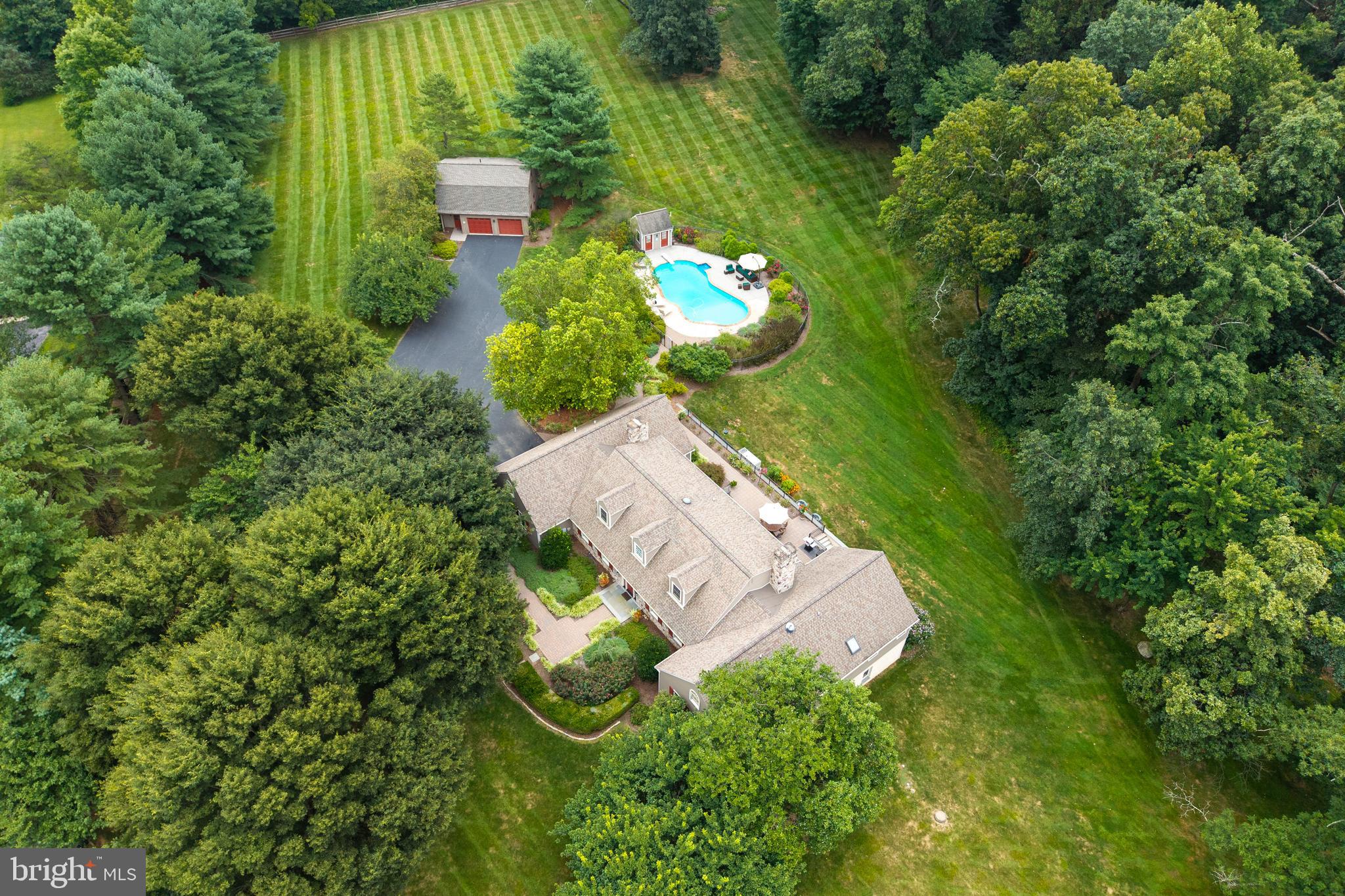 Experience estate living on 4.3 private, gated acres, where a thoughtfully crafted custom home pairs with a fully independent guest residence above a detached two-car garage—perfect for extended family, visitors, or rental income. Extensively renovated in 2007, with major mechanical updates from 2018–2021, this property combines timeless craftsmanship with modern sophistication. Arrive through a tree-lined, automatic gated drive to meticulously landscaped grounds featuring a heated in-ground pool and pool. house with bathroom, changing room, and storage.
The main home’s first floor presents a luminous master suite with windows on three sides capturing sunrise and sunset views. The spa-like bath boasts a skylight, raised ceilings, jacuzzi tub, and custom walk-in closet, while French doors open to a private patio overlooking the serene backyard. Across the hall, a large cedar closet complements two additional bedrooms and a full bath in the west wing, providing both privacy and comfort. Nearby, a cozy sitting room with built-ins, propane fireplace, and pocket doors offers a quiet retreat.
The chef’s kitchen—modeled after a showcase design—is filled with natural light and southern exposure. It features custom cabinetry, Subzero refrigerator, induction cooktop, pot filler, double ovens, warming drawer, beverage fridge, and an oversized granite island seating five. French doors lead seamlessly to the patio, ideal for morning coffee or evening cocktails.
Flowing from the kitchen, the great room centers on a majestic Chester County stone fireplace with barn beam mantle, bread oven, and kettle crane—perfect for year-round entertaining. A paneled dining room, two-story foyer, and light-filled living room flow seamlessly within the open layout. Reclaimed oak floors add warmth, texture, and timeless character throughout.
The east wing blends function and style with a mudroom featuring custom cubbies, tile flooring, and powder room, alongside a spacious laundry with sink and cabinetry. A bright home office with built-in desk, cabinets, plantation shutters, ethernet wiring, and pocket door offers an inspiring work-from-home environment.
Upstairs, two expansive bedrooms span the home’s depth, sharing a full hall bath, while a smaller room—currently a music room—adds flexible space. This level enjoys its own HVAC zone for comfort.
The finished walkout basement impresses with high ceilings, a theater with 110-inch screen, projector, and surround sound, plus abundant storage. Unfinished areas allow for easy expansion and convenient mechanical access.
Outdoor living is exceptional: expansive patios, mature trees, and fully fenced, gated grounds provide privacy, security, and tranquility, ideal for children, pets, or entertaining.
Modern conveniences enhance everyday living: 400-amp service, a 30kW whole-home generator powering both house and pool, WiFi-enabled thermostats, automated exterior lighting, and a separate electric meter for the guest apartment.
At 30 Margaret Court, every detail reflects elegance, comfort, and flexibility, making it far more than a home—a private sanctuary that balances refined living with relaxed, effortless luxury.