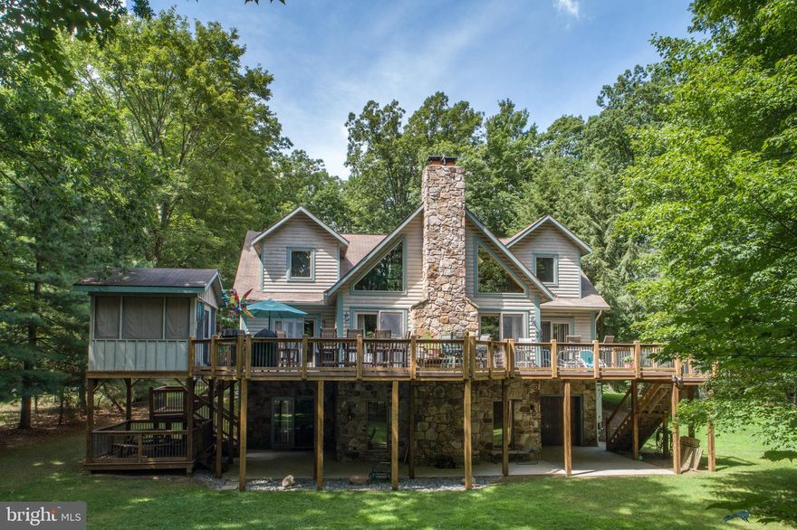 A special lakefront property in Deep Creek's only lakefront and soon to be 18 hole golf community.    Located on the tip of a point and facing south, this 4 bedroom 4 -1/2 bath log retreat offers level frontage, long views from the prime lakefront and dock areas,  great privacy, and virtually no road traffic.   With public sewage and rental restrictions in place, you can be confident that your time at the lake will be uninterrupted.   Three separate living spaces, 2 with fireplaces provide the perfect environment for all activities.  The large deck with screened porch provide additional living spaces.  Each bedroom has direct bath access with 3 facing the lake.  The kitchen is well designed for meal prep regardless of how many cooks are in the kitchen.   A large carport, works well for car protection or outdoor activities when the weather isn't perfect.   A back up generator is available to keep things running when called upon.