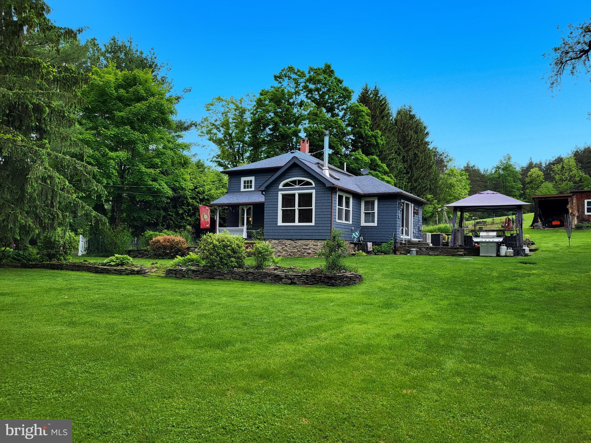 Escape to your own private retreat on 36+ scenic acres with trails, open fields, and two streams, including one right beside the home that's often stocked with trout—ideal for fishing, hiking, or hunting. This updated home blends rustic charm with modern comfort, featuring hardwood floors, exposed beams, and a cozy den with stone flooring, wood stove, skylight, and cathedral ceilings. There are two bedrooms, plus a third currently used as a walk-in closet, and a bonus room downstairs that could be easily converted back into a bedroom. Outdoor highlights include a patio with gazebo and fire pit, a barn, shed, and a converted chicken coop now serving as finished bonus space. A nearby hillside offers breathtaking views of the property and surrounding mountains. Enrolled in the Clean & Green program—property taxes were just $1,441 last year. Zillow and other platforms may misrepresent the location of the house on the map, leading them to incorrectly indicate that the property is in a high-risk flood zone. However, the official FEMA flood zone map—provided as a photo in this listing—clearly shows that the structures are not located within the flood area. Flood insurance is not required for this property.