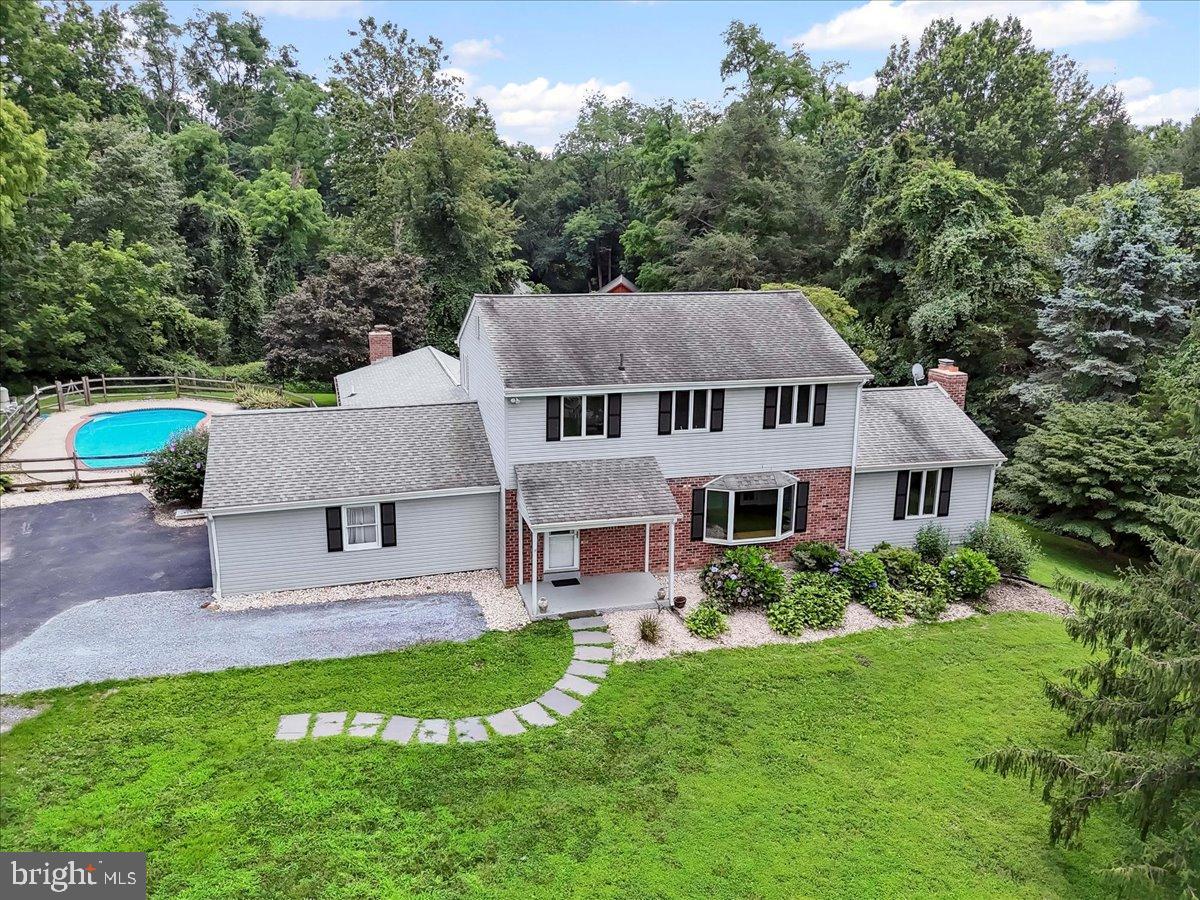 Welcome to this charming brick and siding Colonial home nestled in a quiet, wooded neighborhood within the highly sought-after Unionville-Chadds Ford School District. The main level features a well-appointed kitchen with granite countertops, maple cabinetry, cooktop stove, double oven, dishwasher, microwave, refrigerator, and food pantry. Entertain in the formal dining room with elegant chair rail or relax in the spacious formal living room showcasing a large bay window. The inviting family room offers built-in bookcases, a gas fireplace, and sliders leading to the back deck. A tiled sunroom with sliders to a screened-in porch creates the perfect spot to enjoy all seasons. The main floor also offers a private bedroom suite overlooking the inground pool and a convenient powder room. Upstairs, you’ll find a second bedroom suite along with two additional bedrooms and a full hall bath. The full unfinished basement provides endless possibilities for customization, and the attached 2-car garage offers ample parking and storage. Outside, a fenced backyard and inground pool create your own private retreat.