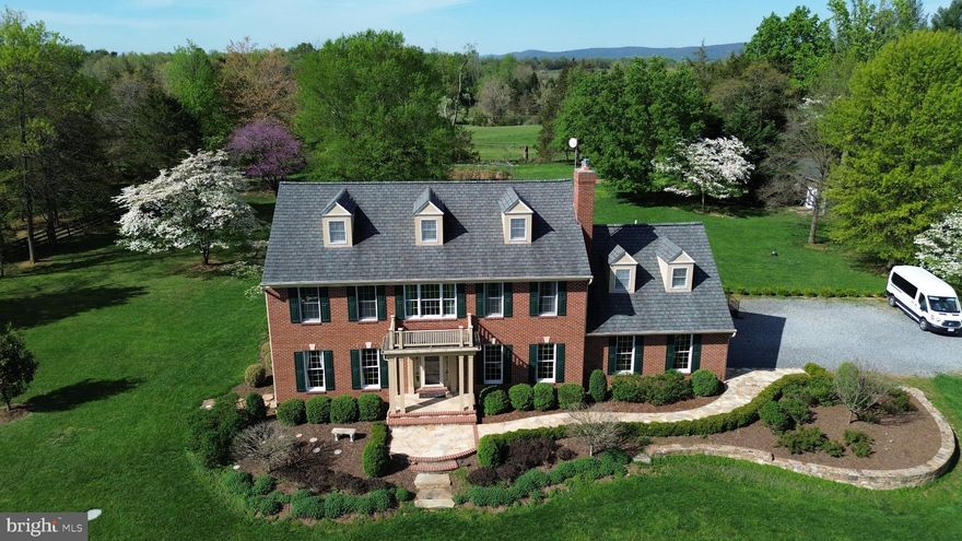 Every day is your getaway at this private oasis on over 3.7 established acres. Beautiful sights year round surround this naturally bright, custom-built all-brick Federal colonial. This beautiful home has it all: 3 levels above grade with 4 generously sized bedrooms, wonderful location, and a gorgeous park-like setting. Even better, this rare find is less than ten minutes from a MARC station that takes you into DC for an easy commute. As you walk up the flagstone path to the inviting front porch, enjoy the countryside views. A two story foyer leads to an updated traditional kitchen with granite countertops, quality cabinets, large island, and breakfast area. You’ll have plenty of living space with a spacious dining room, living room, and family room with a cozy fireplace. On the upper level, an extensive owner's suite has separate vanities and private bath. A bonus room on the third level includes a built-in window seat. Your backyard retreat includes a fenced-in area with a patio, brick walkways, and planter boxes. Other features include multiple outbuildings (artist studio/craft workshop, sheds, chicken coop) and mature blueberry bushes! This country estate has abundant room for parking, entertaining, gardening, and even adding a pool. Now is your opportunity to make this home your own in this special, serene setting only minutes from historic Lovettsville. No HOA.