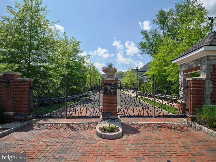 Welcome to the distinguished enclave of Rabbit Run Creek, nestled in the iconic river town of New Hope, Pennsylvania, and distinguished as the only gated community in the area. Upon entering through the private gates, you will discover a refined community of townhomes, presented in clusters of three or as elegant pairs. This end-unit "twin" home, ensconced by the serene woods, offers unparalleled privacy and an array of premium upgrades.  And the location..... tucked away in the back where all you hear is the quiet and peacefulness that you desire.  
The residence features an open-concept floor plan that seamlessly blends luxury and functionality. The gourmet kitchen is a culinary delight, equipped with a large island, a Wolf 5-burner cooktop, a full-size Wolf oven, a built-in Wolf microwave, a Subzero side-by-side refrigerator, a commercial-grade hood, a Miele dishwasher, and countertops and an island in exquisite honed marble.
The great room, anchored by a gas fireplace, boasts an impressive wall of custom-built shelving and bookcases. The formal living room is enhanced by a coffered ceiling and a second gas fireplace, creating a warm, inviting atmosphere. Adjacent to the living room is an office, also with a coffered ceiling, featuring a wall of bespoke bookcases.
Just off the kitchen, there is an expansive half bath and a rear entrance leading to the attached two-car garage. Unique to this unit is a custom elevator, adding an extra touch of convenience and luxury.
Upstairs, you will find three beautifully appointed ensuite bedrooms. The primary suite includes a custom walk-in closet with extensive built-ins, a luxurious full bathroom with a soaking tub, double vanities, a water closet, and a generously sized walk-in steam shower. Each guest suite offers a sumptuous bathroom with a tub and walk-in closet.
Enhancing the living experience is a fully finished lower level, complete with a home gym (equipment not included), a bathroom, a full media center with built-ins and a large TV, and an efficiency kitchen featuring an Elkay sink, a Subzero under-counter wine refrigerator, an Asko dishwasher, a built-in microwave, and a full-size Subzero refrigerator with two freezer drawers below.
With hardwood floors throughout, including all bedrooms, a bluestone rear patio enclosed by custom stone walls for privacy, and extensive moldings throughout the home, this residence is truly a masterpiece of design and comfort.