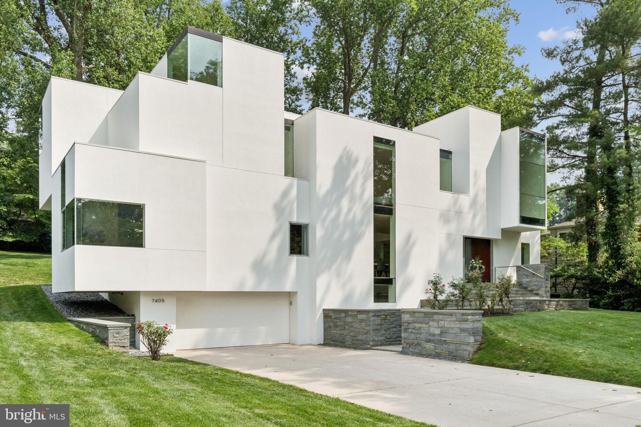 NEW PRICE 7/11!!
Iconic NaCl House – A Modern Architectural Masterpiece
Discover the award-winning NaCl House, an architectural gem designed by internationally acclaimed architect David Jameson. Located at 7405 Helmsdale Road in Bethesda, MD, this striking residence was inspired by the natural isometric formation of mineral rock salt. Completed in 2011, the home features a bold, Tetris-like arrangement of white stucco volumes accented with flush-glazed panels, creating a seamless integration of interior and exterior spaces. For the discerning buyer seeking a truly exceptional residence, this award-winning home is a rare opportunity to own a landmark of modern design. Honored with a 2014 Residential Architect Magazine Design Award, the property stands as a testament to modernist ingenuity and visionary craftsmanship.
Inside, the approximately 4,860-square-foot residence offers thoughtfully designed living spaces centered around a striking double-height living room. This open and fluid layout invites both grand entertaining and intimate moments. Crisp white walls and light ash floors create a minimalist elegance that perfectly complement the expansive floor-to-ceiling windows and sleek glass railings. These elements flood the interiors with abundant natural light, enhancing the home’s bright and airy ambiance. The careful interplay of space and light reflects the architect’s intention to craft a home that feels both dynamic and serene.
Originally built on the foundation of an earlier structure, the home was completely reimagined in 2011, blending modern elegance with structural innovation. Situated on a tranquil half-acre lot, in the sought-after neighborhood Bannockburn Estates in Bethesda, MD, the NaCl House combines architectural splendor with a serene natural setting. This exceptional property features luxurious finishes throughout, including a commanding mahogany front door and elevator, servicing all levels.
Owning this iconic property is a rare opportunity to live in a true piece of architectural history - where luxury, design, and lifestyle seamlessly merge.