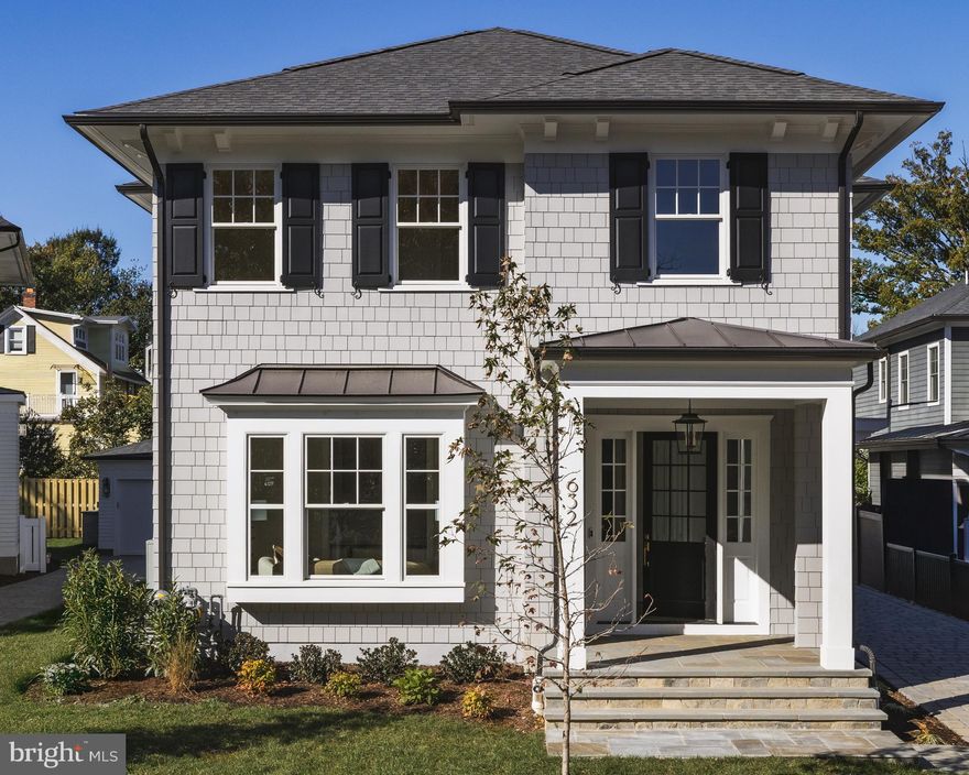 In the coveted heart of Ashton Heights, where lush tree-lined streets meet urban sophistication, 632 North Kenmore Street stands as a statement of modern artistry and refinement. Conceived by the acclaimed Ventura Group, designed by GTM Architects, and finished with interiors by Kelly Knebel Designs, the home has been thoughtfully crafted from the ground up to embody timeless elegance with a contemporary edge.
 
The exterior makes a charming first impression, with gray Hardie shingles, crisp white trim, and dark shutters evoking the quiet luxury of a Nantucket summer cottage. A deep paver driveway along the side leads discreetly to a private detached garage at the rear of the property. The entry, tucked beneath a welcoming portico, opens into a dedicated reception area, with a light-filled den situated just off to one side.
 
Inside, the ambiance is bright and ethereal. Ten-foot ceilings and eight-foot doors lend a sense of scale, while wide-plank white oak flooring and substantial Emtek hardware establish a foundation of quality. Visual Comfort and Hudson Valley light fixtures pair with WAC recessed lighting, adding layers of warmth and visual interest to the clean architectural lines.
 
At the center of the main level, the stair hall serves as a striking architectural core, where a sculptural white oak staircase is framed by soaring windows that flood the space with natural light. Opposite the staircase, the formal dining room is framed by a large wall of glass and perfectly scaled for hosting. A butler’s pantry with wine fridge connects seamlessly to the kitchen.
 
The informal living spaces span more than 30 feet across in a true open-concept layout. The family room features double sliding glass doors that open onto a screened-in porch, creating a seamless indoor-outdoor connection for year-round enjoyment. The adjacent chef’s kitchen is both stunning and functional, with custom Alpine cabinetry, a white oak island, quartz countertops, and a full suite of top-tier Sub-Zero, Wolf, and Cove appliances. A sunny breakfast area, surrounded by three walls of windows, completes the space.
 
Upstairs, the primary suite offers a tranquil retreat overlooking the rear lawn. A generous U-shaped walk-in closet is outfitted with custom built-ins, while the spa-inspired bath features radiant heated floors, a curbless shower, soaking tub, double vanity, and private water closet. Three additional bedrooms are thoughtfully laid out, one with an ensuite bath and two that share a large hall bath with double vanity. A full-size Electrolux washer and dryer are conveniently located in the upper-level laundry room.
 
The lower level echoes the main level in scale and attention to detail. A large recreation room is anchored by a wet bar with wine fridge, while a spacious fitness room and a private fifth bedroom suite offer additional flexibility.
 
The home is fully pre-wired for modern living, with ceiling-mounted surround sound, wireless signal boosters on every level, and a comprehensive video surveillance system, all backed by a 400-amp electrical panel to accommodate future smart home upgrades.
 
Out back, the level lawn is lush, fully irrigated, and perfectly proportioned, a serene and functional backdrop for outdoor entertaining or everyday play.
 
Located just steps from the Orange Line Metro and minutes from Washington, DC, 632 North Kenmore Street is a rare blend of architectural distinction, thoughtful functionality, and timeless design in one of Arlington’s most sought-after neighborhoods.