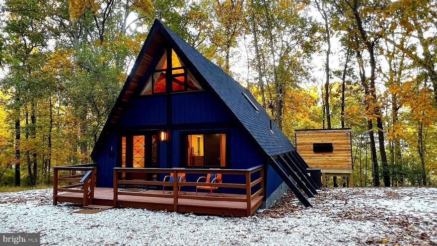 Beautifully renovated, design-forward A-frame retreat tucked on 1.13 private wooded acres in sought-after Marriottsville. Renovated to preserve its original mid-century character (circa 1973) while incorporating modern-day conveniences, this turnkey 2-bedroom, 1-bath home offers a rare blend of timeless style and updated comfort. Highlights include soaring cathedral ceilings, warm wood finishes, a spiral staircase, and an open-concept living space filled with natural light. The updated kitchen features a large island and stylish finishes—perfect for entertaining or relaxing weekend escapes.

Step outside to enjoy multiple outdoor living spaces including a spacious deck, hot tub, and fire pit area, all ideal for year-round enjoyment. The home is perfectly positioned on a gentle hilltop, offering scenic wooded views and a true sense of retreat.

The detached garage with electric provides even more flexibility and can easily be used as a gym, game room, or additional hangout space. A rare bonus feature is the additional mini A-frame structure, offering endless potential. 

With a proven history as a highly successful short-term rental generating approximately $50,000 annually, this property has earned over 100 five-star reviews and ranks among the top 1% of Airbnb properties. Offered fully furnished and turnkey—ready for continued rental use, a private weekend getaway, or full-time residence.

Conveniently located just minutes from the McKeldin area of Patapsco Valley State Park with miles of hiking and biking trails, and approximately 6 miles to I-70 for easy access to Baltimore, DC, and surrounding areas.

A rare opportunity to own a truly unique, design-forward cabin retreat.