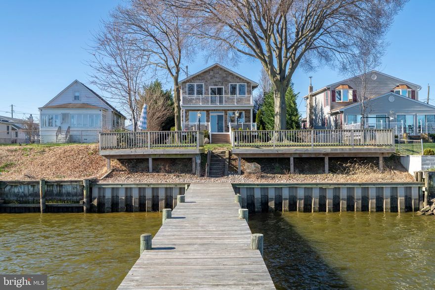 Welcome to your dream waterfront retreat with 50 ft of shoreline at 3930 Glenhurst Road in Dundalk MD! This charming 4-bedroom, 4 full bathroom home offers a perfect blend of comfort and style, with over 2000 square feet of thoughtfully designed living space nestled on a generous 9,100 square foot lot.
Step inside and be greeted by the warmth of hardwood floors that flow throughout the main living areas. As you enter, you'll find an open office space and a first-floor primary bedroom complete with an attached, private bath and jacuzzi tub. You'll be drawn into the open concept main living space by the beautiful view overlooking the water and pier. The modern, upgraded kitchen with large granite island is ready for all of your culinary adventures and combines with the dining and living spaces, allowing you to relax and unwind, or entertain in style.
Upstairs, a second primary suite is your personal oasis, featuring cathedral ceilings and a private bath with a luxurious jacuzzi tub for ultimate relaxation. As if that wasn't enough, this primary bedroom also has its own private balcony overlooking the water, perfect for your morning coffee or to take in the sunset. Two additional bedrooms share a full bath on the upper level. Each bathroom is tastefully appointed, ensuring convenience and privacy for all.
The outdoor spaces are just as inviting, with a large composite deck offering stunning views of the waterfront. Imagine starting your day or hosting evening gatherings while enjoying the serene surroundings. For boating enthusiasts, the private pier with 10,000 lb boat lift combined with a wide body of deep water provides easy access to your aquatic adventures. Great for racing or jet skis! 
A large, 2 car garage offers privacy and convenience.  The garage door openers are mounted on the walls allowing additional space overhead to accommodate larger vehicles.  In addition to the garage space, the driveway can hold 4 cars.  The shed is a great place to house your yard equipment and tools.  
The home also features a basement, perfect for extra storage or a creative workspace. With central air conditioning, washer and dryer, and woodstove, your comfort and convenience are always top of mind.
No flood insurance is required on this home! Major updates include 10,000 lb boat lift (2020), vinyl bulkhead, stone façade front and back, lifetime architectural shingle roof (2017), 50 gallon hot water heater (2020), new flooring, cabinets, lighting and bathrooms remodeled (2018).
Don't miss the chance to make this exceptional waterfront property your own. Experience the perfect blend of tranquility and modern living. Schedule a showing today and start envisioning your new lifestyle!