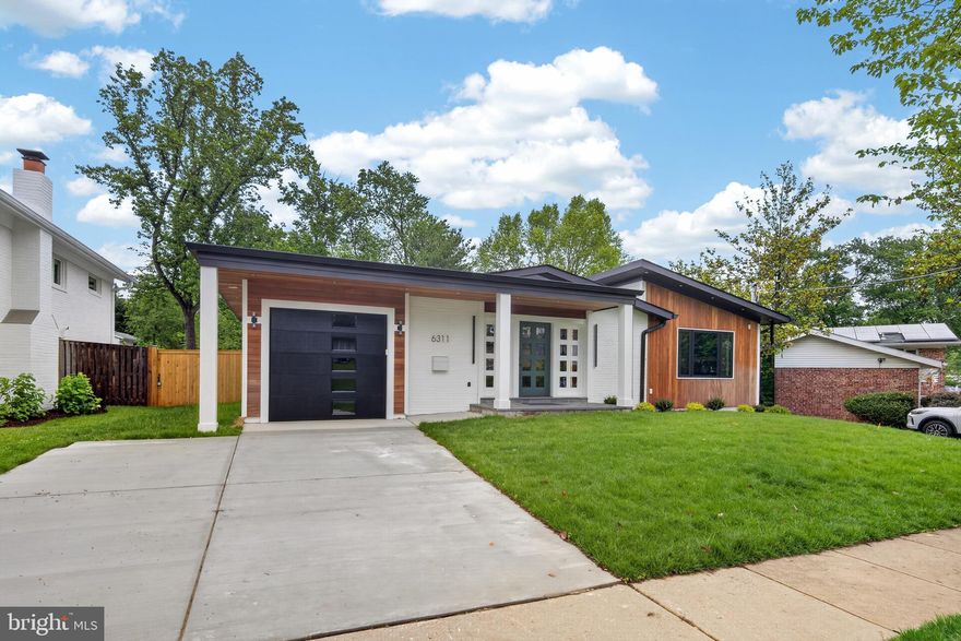 Set on a quiet Ashburton block, 6311 Carnegie is a mid-century split-level taken down to the studs and rebuilt by a registered new home builder. The character of the original architecture is intact — split-level geometry, low horizontal lines, vaulted ceilings with exposed beams in the primary suite — but everything else is new. Six bedrooms, four-and-a-half baths, 3,600 finished square feet across three levels.
The main level is built for daily life and entertaining: an open kitchen, dining area, and family room under skylights, plus a new den or office with a pocket door opening to the deck. The kitchen anchors the floor — German cabinetry, two islands, a 36-inch six burner Wolf range with pot filler, and professional appliances throughout. A mudroom connects the single car garage to the kitchen end of the house.
The upper level holds four bedrooms, three full baths, and a dedicated laundry room. The primary suite has vaulted ceilings with wood beam detailing and a spa bath with soaking tub, three-jet shower, and heated floors.
The lower level adds two more bedrooms and a full bath — or use it as office, gym, and guest space. Two rec rooms walk out to a stone patio and a generous fenced backyard, which is increasingly rare for renovated homes at this size in Bethesda.
Behind the walls: new roof, HardiePlank siding, gutters, Andersen windows, two new HVAC systems, new plumbing and water heater, 400-amp electrical service with all new wiring, and insulation that exceeds code. USB chargers built into outlets throughout. Exterior outlets wired for cameras and motion lighting. One-year builder warranty included.
Ashburton sits inside the Walter Johnson cluster, with Ashburton Elementary and North Bethesda Middle nearby. Five minutes to NIH and Suburban Hospital, ten to Bethesda Row, and quick access to the Red Line at Grosvenor-Strathmore.