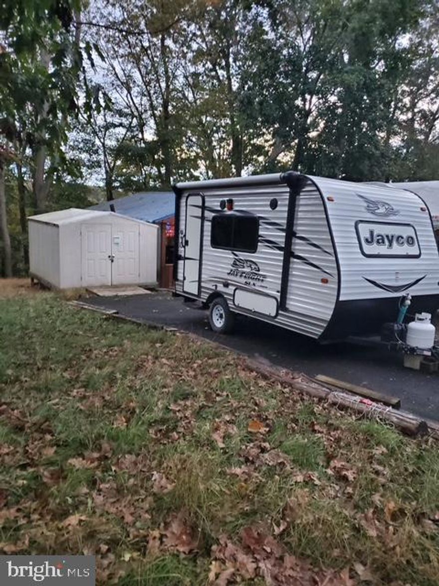 BUY NOW FOR NEXT YEAR!  
Nice level lot with a 2016 Jayco Jay Flight SLX RV tucked away in Riverbend RV Park with a GREAT WATER VIEW!!  This lot is ready for YOU!   Features include water and electric hookups, shed, paved driveway, fire pit and Potomac River access for boating, fishing & swimming.  **LOT BACKS TO TREES FOR ADDED PRIVACY**   Yearly membership to Riverbend Park includes water, sewer/pump out services, electric, trash and access to the park amenities and activities such as pools, putt putt, basketball court, tennis court, holiday fireworks for July 4th, car show, carnival, restaurant, playground, ball field and much more. Riverbend RV Park is located close to shopping, I81 & The C&O Canal for hiking & biking. Own this getaway in as little as 3 weeks. Call today before it's gone! **Gated community-pass required for entry. **Riverbend sales are SOLD "AS IS", CASH only and seasonal.** (Direct TV and Frontier Internet available with service install/hookup).  Call today for details on making this your summer getaway!!