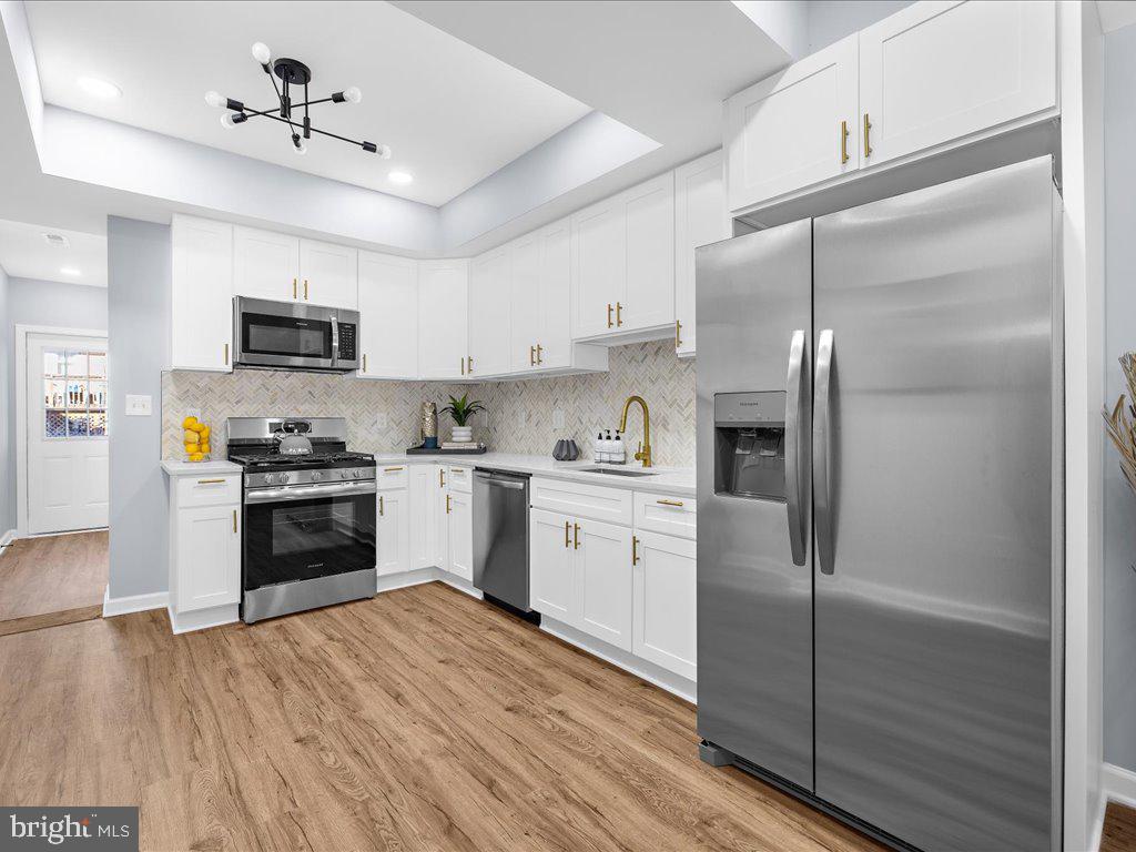 Welcome to this fully renovated rowhome in the desirable Johns Hopkins neighborhood, where modern luxury meets convenient living. This stunning home features two spacious primary suites on the upper level, each thoughtfully designed with custom tile work, high-end fixtures, and elegant vanities. One suite boasts a deep soaking tub, perfect for relaxation, while the other offers a large walk-in shower for a spa-like experience. The main level showcases luxury vinyl flooring that flows seamlessly through the bright and airy living and dining areas, complemented by a gourmet kitchen equipped with white shaker cabinets, quartz countertops, stainless steel appliances, and a chic herringbone backsplash. A convenient powder room and laundry room add to the functionality of this level. The fully finished basement includes an additional bedroom, a full bath, and a versatile bonus room, providing ample space for guests or recreational activities. With its prime location just moments from Johns Hopkins Hospital and Northeast market for a variety of culinary options, this home offers the perfect blend of style, comfort, and accessibility. This home qualifies for the Johns Hopkins Live Near Your Work grant along with many others to assist you with purchasing for minimal cash out of pocket!