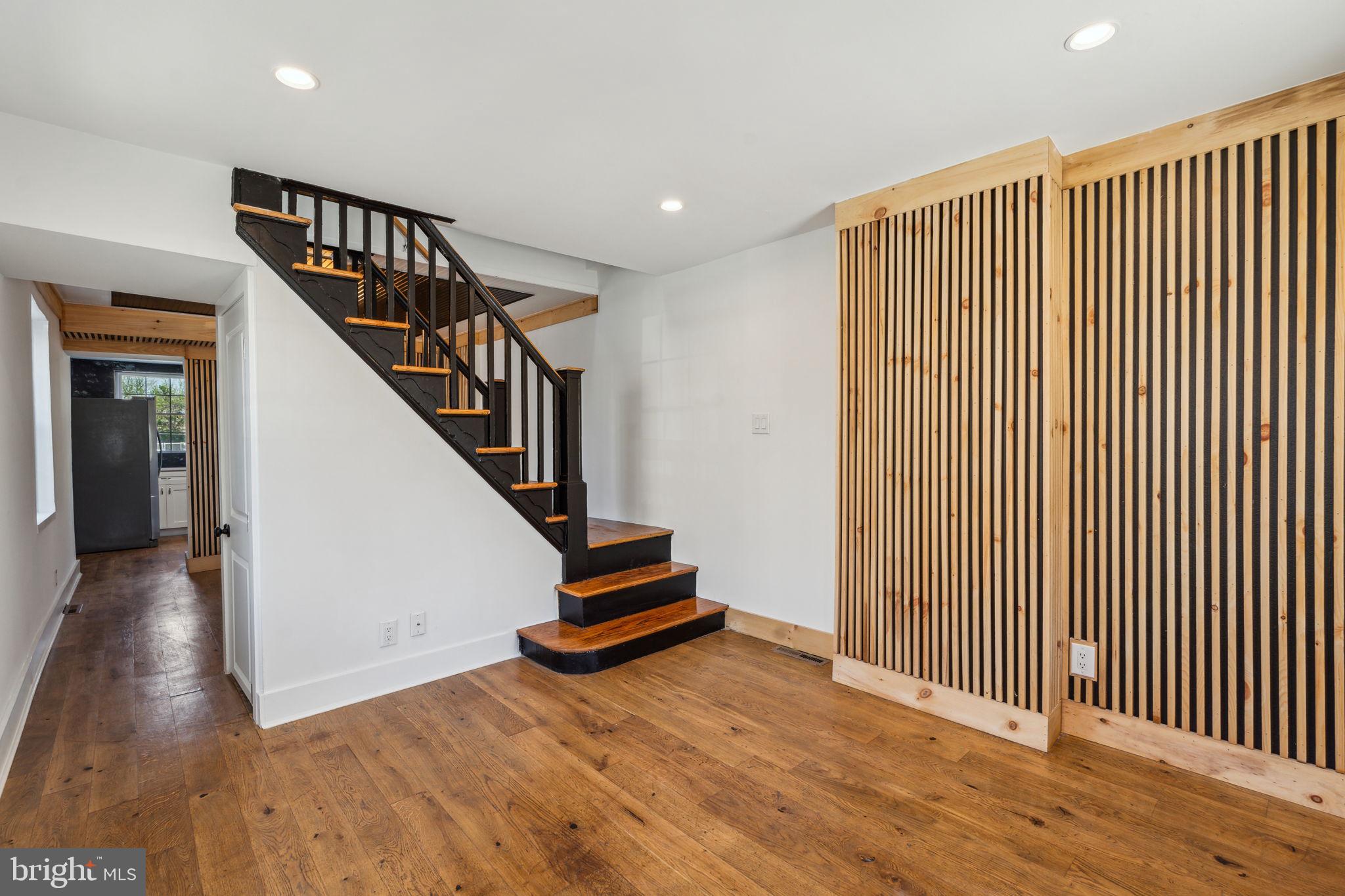 Welcome to this charming 2-bedroom, 1-bath twin home nestled in the vibrant Norris Square neighborhood, surrounded by new construction and the buzz of a growing community. Step onto the large, inviting front porch—perfect for relaxing—and into an open floor plan that seamlessly blends style and comfort. Engineered hardwood flooring flows throughout the main level, complemented by warm wood accents in the dining area that add a touch of character. The kitchen is a modern showpiece, featuring stainless steel appliances, sleek quartz countertops, and a full large-format tile backsplash for a polished finish. Upstairs, you'll find a fully tiled bathroom with a stand-up shower and two comfortable bedrooms filled with natural light. Enjoy added outdoor space with both rear and side yard access. This home is a must-see for anyone seeking comfort, style, and convenience in Philadelphia.