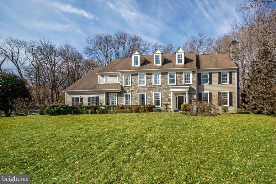 This meticulous colonial enjoys a beautiful setting on expansive private grounds and provides incomparable living for its discerning new owners. Embellished with a stone front, charming shutters and dormers, and a covered entry, this gem makes a statement of character while offering desirable updates and modern amenities. A gracious, airy reception hall with dual coat closets is enriched by a graceful staircase, open arched doorways, and hardwood floors that flow to the main rooms beyond. Exemplifying the traditional colonial style, the foyer is sandwiched by the elegant living room and formal dining room to the right and left, affording a sweeping flow for entertaining. The living room with fireplace invites relaxation and conversation. Serve meals in the wainscoted dining room that connects to a butler s pantry with a Sub-Zero fridge, sink and cabinetry, and the kitchen. No chef can resist the sun-filled kitchen with generous custom cabinetry, storage and counter space. A gas stove and double wall ovens by Wolf, built-in Sub-Zero refrigerator, Sub-Zero wine fridge and built-in microwave give the cook everything needed to whip up gourmet and casual fare. Gather in the light-bathed breakfast room, or step out glass doors to the large rear paver stone patio that extends to a lush green yard. Lovely arched openings lead into the spacious family room with vaulted ceilings, a fireplace with stone surround, picture windows with scenic views, and sliding doors to the patio for easy indoor-outdoor parties. The main level also features an office with wet bar, convenient powder room, and mudroom with a laundry room and 2nd powder room providing entry from the attached to the 3-car garage. Ascend to the 2nd level where your master suite awaits. Complementing the vaulted bedroom is a sitting room, fitted walk-in closet, and serene master bath with his & her sinks, a Jacuzzi tub and shower. Another en-suite bedroom, additional bedrooms and full baths, plus a family room off the landing provide extra comfort. The 3rd floor "suite" is very private and perfect for an office, nanny, studio or other use. A laundry room, basement with a rec area and wine room, central air, and lovely specimen plantings enhance the allure. The neighborhood is exceptional and family-friendly with access to it all.