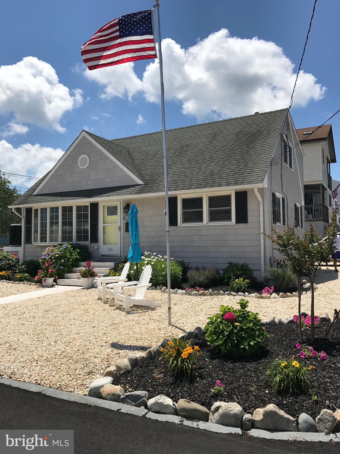 Quaint and Beachy Extra Large Cape Cod situated on a great corner lot. Untouched by Sandy, this well-kept house is perfect for a large family.
Just 9 houses from the beach, this adorable Cape is on a quiet piece of street is also close to all your needs – restaurants & bars, coffee shops, arcades, specialty shops, bike rentals, mini-golf, bait shop, 5 & 10, tennis courts, the marina, library, etc. You name it you can walk to it!
The interior is friendly and casual with a renovated kitchen and 2 renovated bathrooms. There is a large dining table which seats 10, in the bright eat-in kitchen that leads to the sunny, open family room.
There is a large washer and dryer on the ground level for all your wet beach towels right off of the back deck, which has loads of room for al fresco dining.
There are 4 very large bedrooms – 2 upstairs and 2 down, with full bathrooms on each floor. There are a total of 5 Queen beds and 2 twins, with room for more if needed.
This house is ideal for family gatherings or friendly getaways. Large enough to entertain everyone yet cozy enough that it feels warm and inviting.
The floors are all hard wood with tile in the well-equipped kitchen with a dishwasher and all other appliances included.
You can’t go wrong in this Lovely, Large, Beachy Rental in a fantastic location – and it comes furnished.