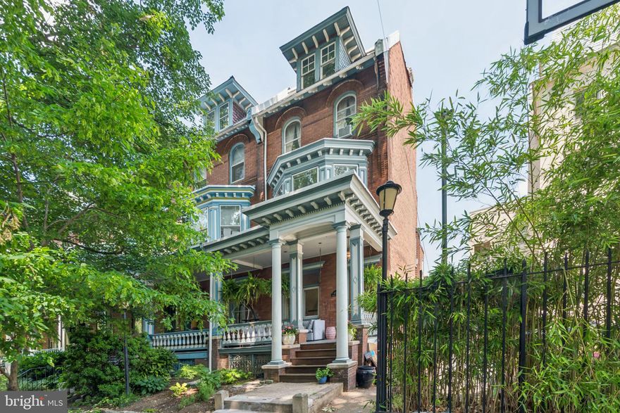 Victorian corner row home boasting 5 bedrooms, 2 full bathrooms and private deck. Located on one of Spruce Hill’s most charming and neighborly blocks and known locally as “Little Osage.” This quiet, tree-lined street offers a strong sense of community while being just steps from Clark Park, the Penn Alexander School, local cafés, and convenient public transportation options. An expansive covered front porch leads into a tiled vestibule and into the main living space, featuring original hardwood floors, high ceilings, crown moulding, and stained-glass windows. A built-in bench with storage sits beneath a large front window, adding both character and functionality. The living room flows into a spacious dining area with bay windows and built-ins. The kitchen is equipped with stainless steel appliances, generous cabinet space, and direct access to a back deck; great for grilling or outdoor dining. Upstairs you'll find three well-sized bedrooms, a full hall bath with a classic clawfoot tub and linen closet. The front bedroom is currently used as a second floor den with built-in shelving and a decorative fireplace. The third floor offers two additional bedrooms with ample closet space and a second full bathroom with a tiled shower/tub combo. There’s also access to a peaked attic for storage or potential expansion. The unfinished basement houses the laundry and offers plenty of extra storage. Just one block from Clark Park and in the Penn Alexander School Catchment, 4215 Osage Ave is surrounded by locally loved spots like Green Line Café, Renata’s Kitchen, Mariposa Co-op, and is within a few blocks of UPenn, Drexel, and trolley lines for a quick commute. This is West Philly charm at its best, offering original craftsmanship, generous space, and unbeatable location.