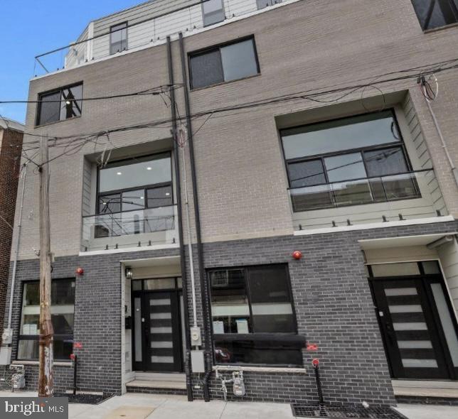 Welcome to The Estates at Queen Village, a rare opportunity to own a newly constructed, meticulously crafted luxury townhome in one of Philadelphia’s most sought-after and culturally rich neighborhoods. Surrounded by tree-lined streets, award-winning restaurants, artisan cafés, and historic architecture, this 4,000+ sq. ft. masterpiece delivers the ultimate blend of city living, modern design, and suburban-style space with the added benefit of a full 10-year tax abatement. Every inch of this 5-bedroom, 5.5-bath residence has been thoughtfully designed to elevate daily living. From the moment you arrive, the grandeur is unmistakable, beginning with a private, heated two-car garage featuring epoxy-finished floors, EV pre-wiring, and double garage doors for enhanced privacy and security. A welcoming foyer with custom storage leads to the fully finished lower level, offering radiant heated floors, a full wet bar with wine fridge, a spa-style bathroom, and a versatile bedroom perfect for guests, a home gym, media room, or office. The main level stuns with soaring 12-foot ceilings, wide-plank white oak hardwood floors, and dramatic architectural detailing, including floating glass-paneled staircases, interior soundproofing, and premium custom millwork throughout. The layout is both functional and elegant, beginning with a formal living area featuring floor-to-ceiling windows that flood the space with natural light. The expansive family room is equally impressive, anchored by stunning custom built-ins, accent lighting, and a sleek gas fireplace finished in marble. At the heart of this level is a showstopping kitchen designed for both style and performance. It features bespoke European cabinetry, a full suite of Viking appliances including a professional-grade gas range, double wall ovens, wine fridge, microwave, and dishwasher, a quartz waterfall island, and designer lighting. Two distinct outdoor areas on this level offer a seamless indoor-outdoor lifestyle: a private balcony off the dining area and a spiral staircase from the family room leading to the rear patio, complete with a built-in gas firepit. The second floor is dedicated to the luxurious primary suite, where oversized windows fill the room with natural light. The spa-inspired bath features heated floors, a deep soaking tub, oversized rain shower, double vanities with LED mirrors, and a custom walk-in closet. An additional en-suite bedroom and second laundry area provide added comfort and convenience. On the third level, you’ll find two additional bedrooms, including one with its own private balcony, along with two full bathrooms. This floor also features an open-concept flex space with a built-in wet bar and wine fridge, ideal for a second living area, home office, or in-home gym setup. Whether you're working from home or prioritizing wellness, this space adapts effortlessly to your lifestyle.
The crown jewel of this residence is the private rooftop deck, where breathtaking unobstructed skyline views stretch across the Philadelphia cityscape. Outfitted with custom lighting and fiberglass tile flooring, this expansive space is ideal for entertaining, relaxing, or hosting under the stars. With an acceptable offer, the builder will include a complete outdoor kitchen and cabana setup, transforming the rooftop into your personal oasis in the sky. Additional highlights include radiant heated floors in both the basement and primary bathroom, two full laundry areas on separate levels, dual-zone HVAC systems, and a main electric panel with a sub-panel for energy efficiency. A comprehensive builder’s warranty offers peace of mind for years to come. With no detail overlooked and no compromise on luxury, this is more than a home. It’s a lifestyle. Located just minutes from Center City, I-95, public transit, and top-rated schools, this is a true standout in the heart of Queen Village. Schedule your private showing today and experience Philadelphia living at its finest.