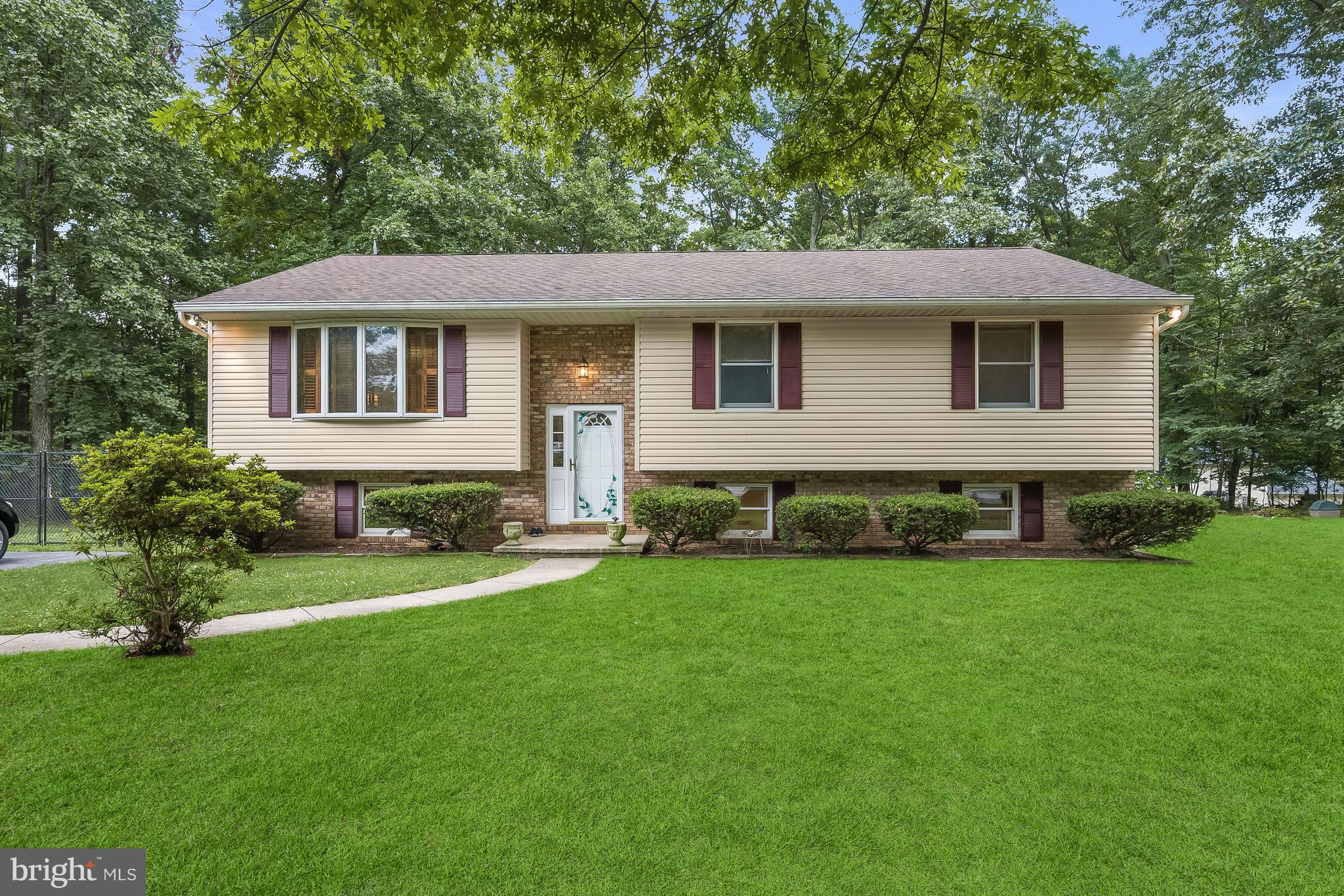 Beautiful split foyer home tucked away in the community of Peach Mill Estates with mature tree lined streets providing a park like setting. Situated on a fabulous 1.03 acre lot offering four bedrooms, three full baths, hardwood floors, and light filled interiors! Living and dining rooms boasting gleaming hardwood floors, wood shutters, and access to the deck and fully fenced backyard; Eat-in kitchen equipped with ample cabinetry, breakfast bar, pantry, and a casual dining area; Spacious primary bedroom adorned with an en-suite full bath; Two additional bedrooms and full bath complete the main level; Lower level family room anchored with a beautiful wood stove, access to the patio, bedroom, full bath, and laundry room; Exterior Features: Deck, fenced level backyard, secure storage, and backs to trees; Community Amenities: Just minutes from Eldersburg | Sykesville, Westminster, and more, offering a vast variety of shopping, dining, and entertainment options. Enjoy nearby Deer Park and Liberty Reservoir for nature and site sightseeing! Area commuter routes include MD-91, MD-32, I-70, I-695,I-795, and MD-140.