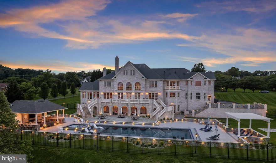 Welcome to this grand estate in Clarksville offering the ultimate blend of timeless architecture and state-of-the-art luxury. With over 14,200 square feet of exquisitely finished living space across four levels, this one-of-a-kind residence with exceptional design and amenities. A sweeping driveway, manicured landscaping, and architectural detailing set the tone for what lies beyond. Guests are welcomed by a stately portico and custom double doors that open to reveal masterful craftsmanship and timeless elegance . The main level opens with a dramatic two-story foyer showcasing dual curved staircases, arched windows and marble floors. Brazilian cherry hardwoods, detailed moldings, and lighted niches carry throughout the home. The gourmet kitchen features Viking Professional appliances, a 48-inch gas range with griddle, dual dishwashers, microwave and oven, warming drawer, and a six-foot-wide refrigerator/freezer. Two oversized islands—one with a prep sink and instant hot water—make entertaining effortless. Adjacent, the great room is anchored by a gas fireplace and framed by expansive windows, with a second-story overlook that adds architectural interest. A richly appointed library or office includes built-in bookshelves, a wet bar, and an undercounter refrigerator—ideal for remote work or reading. Upstairs, the primary suite offers 12-foot ceilings, a sitting area, kitchenette, balcony, double-sided fireplace, and a walk-in closet with a nine-foot center island. The spa-inspired bath features radiant floors, a two-person River Bath jetted tub, a frameless glass shower, dual vanities, and comfort-height toilets. Three additional en-suite bedrooms, each with walk-in closets and private baths, complete the second level. The fourth floor offers two more bedrooms, including a fully renovated en-suite—perfect for guests or staff—and a spacious storage room. The fully finished lower level is tailored for entertaining and recreation. A secondary foyer opens to a custom bar with granite countertops, glass cabinetry, wine storage, and seating. A fully automated theater boasts tiered recliners, surround sound, and a snack bar. A light-filled billiards room connects to the backyard and includes a second bar and space for games. A secondary kitchen, full-size appliances, and patio access enhance guest comfort. Additional spaces include a fitness room, a music or flex room, and a second laundry area. Outside, the estate boasts resort-style amenities. The flagstone terrace features brick stairs with tread lighting, brick columns, a pool with a 10-foot tanning ledge and multi-color LED lights, and spa. The veranda offers ceiling fans, built-in speakers, and accent lighting. A custom firepit with built-in seating and a pergola create cozy gathering areas. The outdoor pavilion is the crown jewel of alfresco living—offering a full kitchen with grill, side burners, warming drawer, microwave, refrigerator, dual bar sinks, undercounter drawers, and a trash compartment. A 75” TV, electric fireplace, ceiling-mounted speakers, and a full bath with an oversized shower complete this extraordinary space. A second built-in grill and strategically placed rock speakers enhance ambiance and function. Whole-home systems include a commercial-grade elevator servicing all four levels, Lutron lighting and shades, a 32-zone prewired audio system, prewired intercom, two central vacuum systems, Wi-Fi-enabled garage doors, and Pella windows with UV protection and retractable screens. Security is comprehensive: a full alarm system tied to the Lutron lighting activates all interior/exterior lights and floodlights. Features include motion, glass-break, smoke, and carbon monoxide sensors,  plus eight-camera surveillance with NVR. With its elegant design, amenities, and smart-home systems, 5912 Clifton Oaks Drive is a rare opportunity to own.