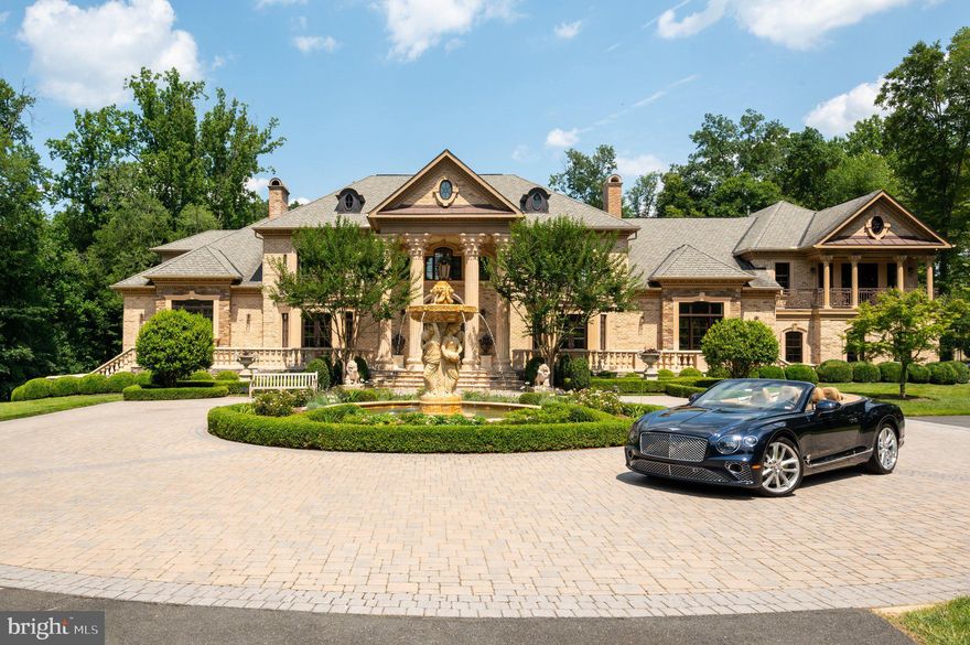 Welcome to Casa Divina,  located at 633 River Bend Road, a classic Great Falls mansion, is poised in regal elegance yet strikingly modern. Positioned within a luxurious five-acre expanse, it has been completely reimagined. A distinctive collaboration between renowned designers and builders has given rise to this unparalleled living experience.

Enter through the majestic gate onto a 400-foot driveway leading to the exterior of Casa Divina, a testament to intricate construction and design. A captivating Italian fountain, the centerpiece of the motor court, welcomes visitors with its soothing melody.

Beyond the double-wrought iron doors, discover a seamless blend of contemporary refinement and timeless grandeur. The grand foyer, adorned with intricate millwork, wrought-iron railings, a double staircase, and twin nine-foot chandeliers, sets a tone of sophistication that resonates throughout the home.

The palatial formal rooms, grand in scale yet intimately appointed, offer the perfect balance for both lavish entertaining and comfortable living. The fully renovated chef's kitchen, a culinary masterpiece, boasts scenic vistas, inlaid Jack Rosen custom cabinetry, commercial-grade Wolf and Miele appliances, and unbroken slabs of honed Altissimo marble.

The main level's primary suite is a tranquil retreat featuring decorative lighting, including a Vertigo Pendant and an Artemide Mercury Suspension Chandelier. The ethereal primary bathroom, illuminated by a Firenze crystal chandelier, offers a freestanding soaking tub, an enclosed steam shower, and radiant-heated marble floors. Dual walk-in closets offer an abundance of space; one even spans two levels and includes a private staircase. On the upper level, a secondary primary suite, alongside other guest suites, each with intricate ceiling designs, offer ensuite baths.

The lower level, fully tiled in limestone, reveals a world of indulgence: a full-sized wine cellar, a bar with a full kitchen, and a paneled billiards room. Facilities such as the fitness center, sauna, and professional home cinema blend old-world charm with modern comfort.

Outside, the estate's grounds unfold as a wonderland of luxury. The 45-foot heated, mosaic-lined pool is ensconced in limestone patios and mature plantings. The perennially lush landscape is maintained by a 71-zone irrigation system. Integrated uplighting enchants the entire property, and the grounds enchant further with a whimsical playground reminiscent of a fairytale.

Equipped with state-of-the-art technology, Casa Divina offers effortless control and connectivity at all times. Nestled in the heart of coveted Great Falls and adjacent to the roaring waters of Great Falls Park, this residence represents a new and unparalleled paradigm of estate living.