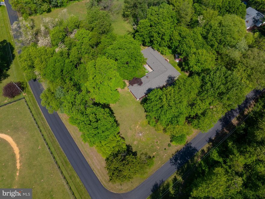 HORSES ALLOWED!  This 4 bedroom,  2.5 bath  all brick L-shaped rancher offers country living at its best.  The huge kitchen boasts corian counters,  a breakfast bar,  a center island with a propane fueled cook top,  a double wall oven ,  an abundance of cabinetry with pantry,  as well as access to a delightful 24 x 24 screened porch that leads to the rear yard. 

RECENT UPGRADES INCLUDE:
* NEW ARCHITECTURAL ROOF   12/25
* NEW GUTTERS/DOWNSPOUTS   2/26
* NEW PRESSURE TANK     3/24
* NEW WELL PUMP   10/24
* WATER HEATER   12/18

 The SEMI-OPEN  floor plan is complete with hardwood floors,  a sunken living room with a wall length brick fireplace,  a family room containing a stone fireplace and wood stove insert and a very large dining area.  The bedrooms are serviced by a full bath and the primary bedroom offers large windows and a private bath with a walk in shower.  A 1/2 bath is beside the kitchen.
On the west side of the home stands a detached hobby shop/playhouse and in the rear center of this awesome 3.06 acre corner lot is a detached lawn/garden building that can be converted to a run-in shed for a horse or two. 
This Shiloh Subdivision is a long standing community with paved streets,  mature trees (including  willow, mimosa and maples) and space to enjoy your time away from work.
The easy major highway access is close to shopping,  schools ,  businesses ,  as well as The Charles Town/ Hollywood Casino and Horse Racing.
ENJOY COUNTRY STYLE LIVING AT ITS BEST  AND YOU'RE WELCOME TO BRING A HORSE OR  2.