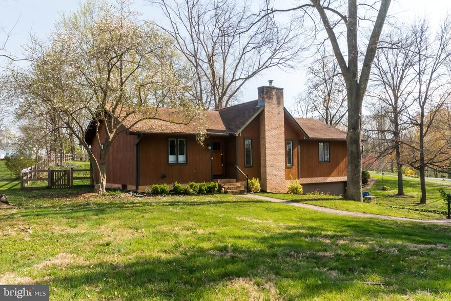 MULTIPLE OFFERS.   Highest and best due by Monday at 8 PM.  Nestled perfectly in the mature wooded neighborhood of Woodbrier Manor, this lightly wooded property features a beautiful move-in ready rancher built with natural materials and accented with a brick foundation and chimney.   The three bedroom and two full bathroom home has been renovated and upgraded throughout while highlighting its character features like the cathedral ceilings, large casement windows, and wood burning stove.  The front entry foyer flows into the open living area with its high ceilings and low-maintenance LVP flooring, nestled by the warmth of the Timberwolf fireplace - a great area for gathering.  The open floor plan leads into the dining area and a kitchen that features a beautiful quartz countertop, subway tile backsplash, upgraded KraftMaid cabinets, Bosch dishwasher, and matching stainless steel Whirlpool oven and refrigerator.  The split floor plan provides a private primary bedroom that features a large walk-in closet with custom shelving built-in and an en suite bathroom with updated vanity and LVP flooring.  The two large guest bedrooms share an updated guest bathroom with similarly updated vanity and flooring.  Extra space for a workout room and storage can be found in the basement along with access to the large garage with included shelving and workshop space.  The exterior has been nicely landscaped, highlighted by a natural outcropping of rock and planted arborvitae trees for added privacy.  The back yard is very pet friendly and has a large deck surrounded by wood board fencing with a vinyl mesh lining, but there is green space on all four sides of this home to enjoy.  This property really has it all; schedule an appointment now to secure a showing time before it's too late!