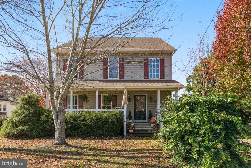 Welcome home to this inviting colonial, located on a quiet dead-end street, where a wide covered front porch sets the tone for warm gatherings and peaceful mornings. Step inside to a bright, open two-story foyer with hardwoods throughout the main level. The living room features a striking brick fireplace with a large hearth and classic mantle, creating a cozy centerpiece for the open floor plan that flows into the dining area and kitchen with rich wood cabinetry, recessed lighting, and thoughtfully designed spaces for cooking and entertaining.

Tucked privately on the main floor, the primary suite offers the ease of first-floor living with a walk-in closet and an ensuite bath featuring a jetted soaking tub and separate walk-in shower. A spacious laundry/mudroom is also on this level for added convenience.

Upstairs, a large loft provides flexible space for work, hobbies, or relaxation. Two additional bedrooms, a bonus room, and two full bathrooms complete the upper level.

Step outside to a serene backyard dotted with mature trees—perfect for outdoor enjoyment. An inviting fire pit area and two outbuildings, including a barn-style shed, provide options for storage, gardening, or workshop use.

A home that combines timeless design with modern comfort, offering spaces made for both relaxation and entertaining in a peaceful setting.