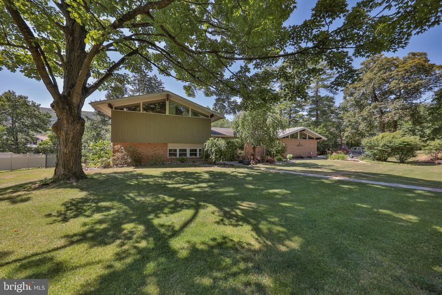 A BEAUTIFUL, PRIVATE AND PEACEFUL SETTING! 3+ BR, 3BA California Style Split Level home nestled on less than an acre corner lot in the quiet neighborhood of Palmerton’s Residence Park! The bright foyer welcomes you that expands to an open floor plan with a comfy, spacious living and dining rooms with wood floors and vaulted ceilings. The recently renovated luxury kitchen includes new cabinets, granite counters, a 10' center island equipped with an island microwave drawer, wall ovens, copper farmhouse sink, stainless appliances, walk-in pantry and large windows adds for natural lighting! Ascend to the upper floor to 2 equal size bedrooms and a full remodeled bathroom. Spacious Master Ensuite has (4) closets, a wood fireplace, vaulted ceilings and remodeled bathroom! Family room, office (or 4th BR) laundry and full bath are on the lower level. Love to entertain? Walk out to the rear covered patio with an exterior kitchen equipped with natural gas grill, sink and stone countertop! Perfect for large gatherings! The enclosed rear porch (off the dining room) provides the perfect setting for an all season room to enjoy the peaceful surroundings . . . any time of the day, all year long! Full unfinished basement, workshop and space for all your storage needs. A  2-car garage, long driveway for additional off-street parking. Front and rear yards include landscaped gardens, flowering plants, stately shade trees, and a firepit are all apart of this homes beautiful setting! TRULY AN IMPRESSIVE HOME!