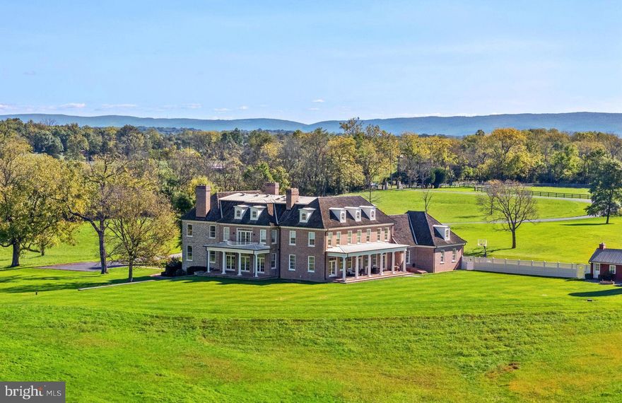 The masterpiece 67-acre estate of Limestone Farm features a stately federal style manor house, with origins dating to the 1790’s. Meticulously and completely renovated and expanded in 2010, the manor house has now over 11,000 square feet of elegant living space. Throughout the construction, tremendous attention was given to preserve the homes’ history while making the expansion seamless.  As one ascends the front steps, one notices the front porch ceiling which showcases the hand painted crest of the family who built the original home.  One then enters the foyer with its beautiful heart pine flooring, mahogany newel post, handrail, and staircase in its original detail, and fully restored with great attention given to its structural integrity. Many of the details of the foyer were carried through to the new and gracious back hallway with its grand heart pine staircase. This hallway separates the kitchen from the great room and creates a wonderful entertainment flow. To enhance the seamlessness of the old to the new, reclaimed heart pine flooring was installed throughout the main and upper levels. Built of local limestone and handmade oversized brick, the roof is of extra premium cedar shake shingles imported from Canada. 

The elegant William Ohs Kitchen, with its superior craftsmanship, is the epitome of a truly beautiful chef’s kitchen. The custom cabinetry is graced with Carrara marble countertops and backsplash and Waterworks fixtures. The appliances include Wolf, Sub-Zero and Miele, and a large pantry offers additional storage. At one end of the kitchen a spacious breakfast area opens out to a charming brick terrace with pergola.

This stunning home is further enhanced with Ralph Lauren wallcoverings, window treatments, fabrics and furnishings. French doors and large windows provide beautiful natural light, with many of the doors opening out to terraces and covered porches from which to enjoy the beautiful and very private countryside. A gracious and level lawn off the back terrace provides the ideal location for a future pool.

The lower level has 5,000 sq. ft. of unfinished space with both interior and exterior access, providing room for a home theatre, gym, etc. The mechanical room is on this level and houses part of the Geothermal heating and cooling system.  One also has access to the basement level of the original home with its large fireplace. While in this section, look at the ceiling to see part of the new support system which has given the original home its very solid feel. Also, look for carvings dating from the early 1800’s and admire the mantels original to the home, now stored on this level. 

Limestone Farm has 2 additional structures which include a guest house and a stable. The guest house sits close to the main home and features a living/bedroom combination, a full bath, and a kitchenette. The stable, originally a bank barn, was carefully moved 200’ to its current location, redesigned and features a vaulted ceiling, a wide center aisle, 8 stalls, and a tack room. Adjacent to the barn are 3 large paddocks, 1 smaller paddock and 10 acres of flatland ready for more paddocks, outdoor ring or covered arena. This farm is located in prime Blue Ridge Hunt Territory. Along much of this property’s western edge is a section of Opequon Creek, a tributary of the Potomac River. Limestone Farm is truly an extraordinary estate.
