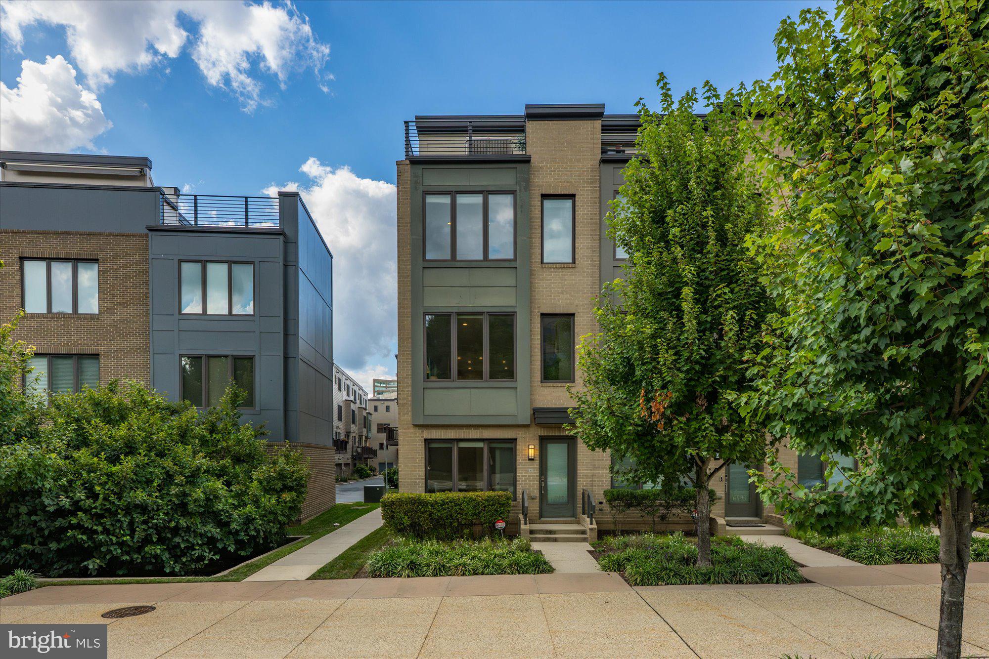 Discover the advantage of an end-unit with extra natural light in this stunning four-story townhome nestled in the lively Montgomery Row community. Built in 2016 by the acclaimed EYA Builders, this home is a testament to superior craftsmanship, elegant finishes, and well-conceived spaces throughout, with over $123,140 in total upgrades and enhancements. The entry level welcomes you with a spacious one-car garage, leading into the home with cozy heated floors and a bright, versatile space perfect for a home office or home gym. Additionally, there are two parking passes available, one for on-street parking and one for the parking garage, offering ample parking options. Ascend to the main level, where the open-concept living area is ideal for entertaining. The gourmet kitchen features stainless steel appliances, a large island and breakfast bar, pantry, and a private balcony with a gas line perfect for grilling. This space flows seamlessly into the dining and living areas, highlighted by a cozy gas fireplace. The third floor is dedicated to relaxation, featuring a luxurious primary suite complete with a custom walk-in closet and a spa-inspired bathroom. Additionally, there is an additional bedroom with its own bath and a conveniently located laundry area. The top floor serves as an entertainer’s paradise or a third bedroom suite, offering a vast flexible space with access to the third full bathroom, in-ceiling speakers for an enhanced audio experience, and a breathtaking rooftop terrace with panoramic views. This remarkable home provides a perfect blend of luxury, comfort, and convenience, with easy access to I-270, Westfield Montgomery Mall Transit Center, medical buildings, shopping, and popular restaurants—an opportunity you won't want to miss!