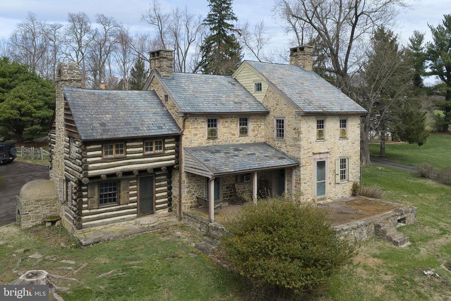 Opportunity and Potential: Own a piece of American History in the heart of Bucks County. This c.1760 stone farmhouse offers incredible potential for the right buyer. This one-of-a-kind residence is a rare fusion of an original log settler’s cabin and a handcrafted stone home, standing exactly as early colonials intended: first the cabin, then the stone additions—preserving a story that has endured for over 260 years. Whether you choose to conserve its current character, bring it back to its full historic glory, or thoughtfully update certain elements, the level of restoration is entirely up to your vision. Properties like this provide a rare chance to create a true legacy estate while adding value through customization. Inside you’ll discover:
- 4 fireplaces on the main level, each adding warmth and historic charm
- 1 additional fireplace in an upstairs bedroom currently covered but with potential to be reopened and restored
- A rare beehive oven, a true historical gem
- Original German hardware: door hinges, locks, and fittings
- Authentic window frames, doors, and craftsmanship that reflect 18th and 19th century construction
- Every room has an exterior door, six in all; the dining room has two!
Every detail tells a story. Every room transports you. 
Huge double doors lead from the dining room to the kitchen, creating a grand statement. In the living room a straight staircase leads up to the second floor, then continues to the attic—a rare feature in a vintage home. The high ceilinged attic makes the third floor a good candidate for a bedroom. A second back staircase runs from the bedroom in the log section to a mudroom downstairs, opening off the driveway. Outside, a large in-ground concrete pool and outdoor grill provide a perfect setting for entertaining, with the yard fenced for your animals. Most surprising is the stunning two-story stone watertower in the rear corner, hosting the well and pressure tank. A detached two-car garage/barn completes the country setting. The garage second floor is filled with light, perfect for a studio. You have an expansive view of the picturesque preserved farm across the road, providing serene, pastoral scenery, increasingly rare to find. You’re just minutes away from Peddler’s Village with its great shopping and dining experiences and ten minutes from New Hope. The seller is attaching an architectural proposal for a full restoration of the house, as well as a Home Inspection report. Property is being sold “as-is”.