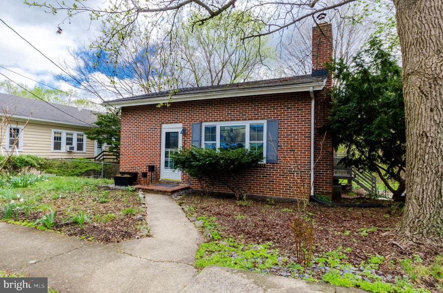 Absolutely charming 2 bedroom bungalow within earshot of the babbling Town Run stream in the heart of Shepherdstown.  The rear yard is a private retreat in the face of a downtown set alongside a thriving university.  The modern interior design ties in beautifully with the traditional homestyle and historic nature of the town.  A free-standing pellet stove serves as centerpiece for the main floor living space and an efficient source of heat in the winter months.  Two-story ceilings and exposed beams add to the charm of the house, and the kitchen is a stand-out - complete with butcher block countertop, coffee bar, updated appliances, and open shelving.  Tastefully updated, the full bathroom carries the wooden counter and top mounted sink on a tile floor with a whirlpool shower and tub combo.  Upstairs there are two adequately sized bedrooms packed full of character with hardwood flooring and exposed beams.  Downstairs is partially finished to create a secondary entertainment space in the cozy den.  The unfinished basement portion is used for laundry, storage, and workshop space and exits to the rear yard.