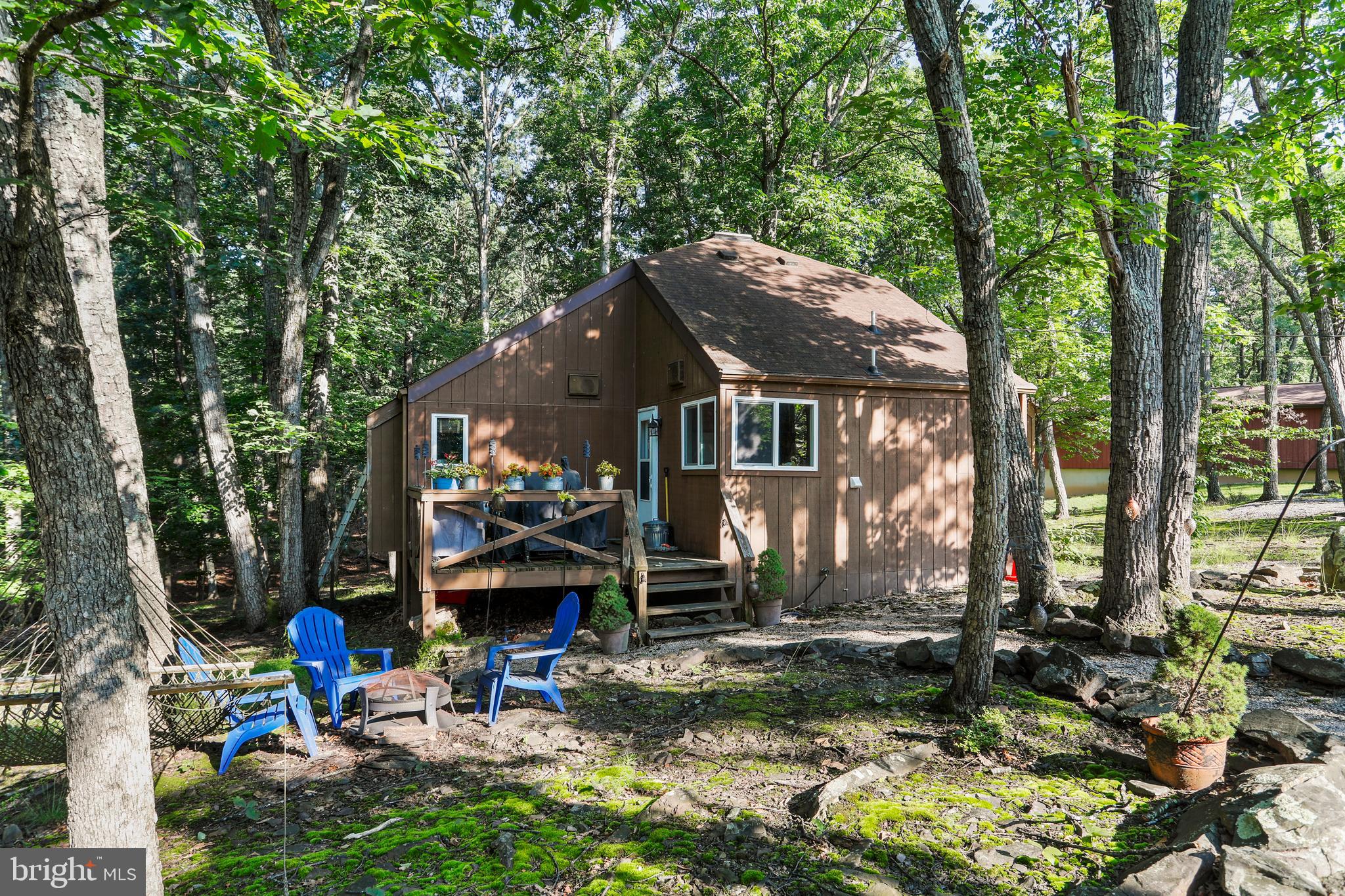 MOTIVATED SELLER!
Tucked-Away Treasure on Cayuga Trail
495 Cayuga Trail, Hedgesville WV 25427
Welcome to a cabin that's been thoughtfully cared for and quietly loved-offering a rare blend of character, comfort, and woodland charm. Nestled on a .83-acre wooded lot in The Woods, this
3-bedroom (including loft), 1-bath retreat is the kind of place that makes you slow down and stay a while.
Inside, you'll find:
• A warm and inviting wood-burning fireplace in the main living area
• Laminate flooring in the kitchen and bath, with updated butcher block-style counters
• All new appliances, including a stackable washer and dryer
• Newer windows throughout, helping brighten the interior and boost energy efficiency
• A bright and functional kitchen open to the living space for casual gatherings
• Select furnishings convey, offering a head start on your move-in or weekend escape
A covered porch-accessed from both the main living area and the primary bedroom-adds a wonderful outdoor living space to enjoy quiet mornings or evenings under the trees. The adjacent deck offers additional room to entertain or relax.
While the home retains the rustic charm of its original 1977 design, thoughtful updates and pride of ownership are evident throughout the interior. The lot features a natural landscape with mature trees and subtle plantings that feel right at home in the woods. Recent exterior cleaning has refreshed the roof and deck.
Includes a Class B Membership to The Woods Club with access to recreational amenities available through a one-time $3,150 initiation fee and $1,600 annual dues.
Whether you're looking for a peaceful weekend escape or a cozy full-time residence, this cabin offers a chance to own a piece of serenity in a well-loved mountain community.