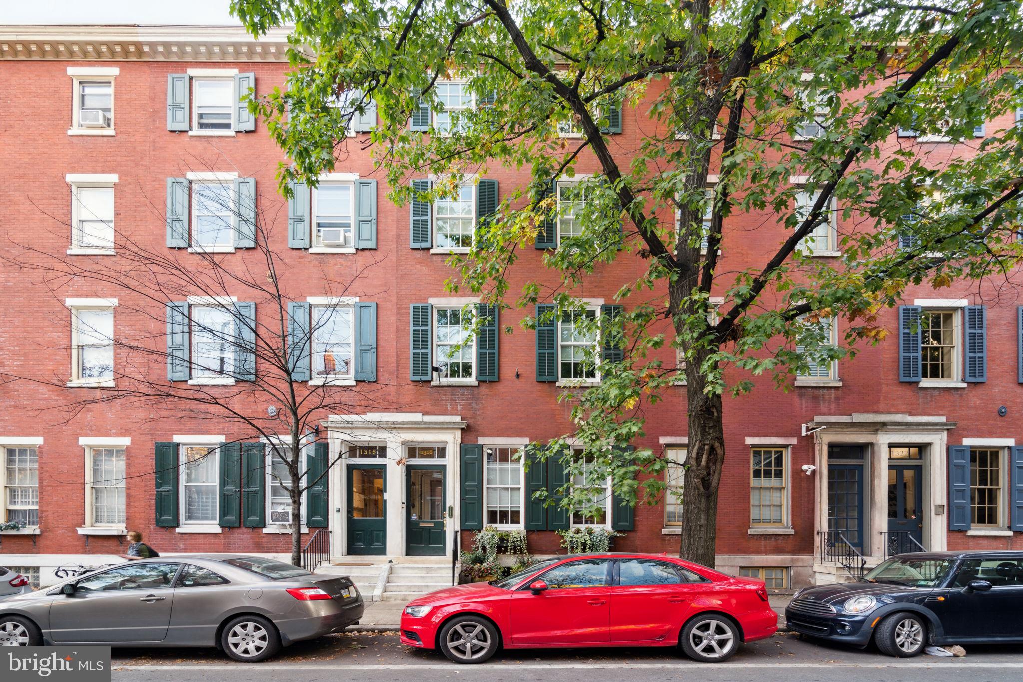 Impeccable renovation of a historic five bedroom, three full plus two half bathroom home with large deck along storied Pine Street. This residence boasts incredible space, original details, modern updates, and one-car garage parking. Enter through a vestibule into the foyer that features gorgeous wood floors with inlay, crown and baseboard molding, and access to the grand central staircase that winds up each level of the home. The foyer leads into the stunning great room with ample space for living and dining. The great room has soaring ceilings, spectacular molding, three large windows, a gorgeous fireplace, stunning chandelier, and beautifully restored original hardwood floors. Past the great room is the fully equipped modern kitchen and access to the lower level with a storage room and workshop as well as garage access. The eat-in chef’s kitchen has an exposed brick wall, white cabinetry, granite countertops, a large island with seating, mirror backsplash, and stainless steel appliances including a stacked Kitchen Aid microwave and oven, Kitchen Aid gas range, Samsung fridge, and Fisher & Paykel dual dishwasher. There is also a powder room and access to the garage from the kitchen. Up a flight of stairs are French doors leading to the spacious rear deck with pergola and ample room for outdoor dining and entertaining—the deck sits atop quiet, tree-lined Waverly Street. Adjacent to the deck is the light-filled family room that boasts another spectacular fireplace, high ceilings, and a fully stocked wet bar with wood cabinetry, granite countertops, wine fridge, and THOR ice maker. On the front end of the second floor is the spacious primary bedroom with great natural light, built-in shelving, a decorative fireplace, custom walk-in closet, and luxurious ensuite bathroom. The primary bath has black marble floors, white tilework, a double vanity with granite top, and a glass stall shower. On the front end of the third floor is another large bedroom with fireplace, walk-in closet, and ensuite full bathroom that features updated flooring, exposed brick, and decorative fireplace. To the rear is a sunlit office (that could be used as a bedroom), a third full bathroom with glass shower and skylight, and the laundry room with stacked LG washer/dryer. On your way to the fourth floor, you will pass a stunning circular skylight that showers the staircase in gorgeous natural light. The fourth floor includes an exercise room, a game room with more closet space and a powder room. Both the exercise and game room can be used as bedrooms. Additional home highlights include original wood floors and trim, recessed lighting, remodeled and updated mechanicals, ample storage/closet space, and ceiling fans throughout. Conveniently located steps from the Avenue of the Arts in the Washington Square West neighborhood in close proximity to incredible restaurants, parks, cafes, retail, theaters, and cultural institutions, as well as Jefferson and Pennsylvania Hospitals.
