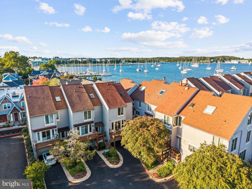 Experience elevated water oriented living in this beautifully updated four-level luxury townhome offering tranquil Severn River views and a rare sense of privacy within one of Eastport’s most coveted gated communities. Recently refreshed from top to bottom, this home features brand-new decks with contemporary cable railings, a new A/C unit and heat pump, fresh interior paint, and a new rear privacy fence—blending modern comfort with timeless sophistication. The main level welcomes you with an open, sun-filled layout that flows effortlessly from the gourmet kitchen—complete with Bosch stainless steel appliances, granite countertops, larger center island and custom cabinetry—to the dining and living areas framed by expansive glass doors leading to a spacious deck overlooking the water. Rich hardwood flooring, recessed lighting, and a sleek built-in entertainment unit with beverage refrigerator create a polished yet inviting atmosphere perfect for entertaining. Upstairs, discover a large guest bedroom with vaulted ceilings and the primary suite that offers a private balcony with serene river views, dual closets, and a spa-inspired bath featuring a soaking tub, separate frameless shower with dual shower heads and bench seating, and dual vanities. The top-level private loft/ bonus room features an open skylight with great panoramic views of Annapolis and cedar closet that provides ample space for family or guests while the private lower-level bedroom with an en-suite bathroom and a walkout patio is perfect for visitors or a quiet home office. Additional features include an oversized 1-car garage with extended driveway and ample additional parking within the community, custom storage systems, integrated blinds, and meticulous craftsmanship throughout. Enjoy a lifestyle of sophistication and ease- walk to Eastports waterfront restaurants, local pubs, and marinas, or simply relax on your private balconies with front-row views of the Blue Angels flyovers, the Parade of Lights, Annapolis’ summer fireworks, and the city’s celebrated boat shows. Residents also enjoy optional membership access to the on-site marina and pool—available to join for an additional cost—offering resort-style amenities just steps from your door.