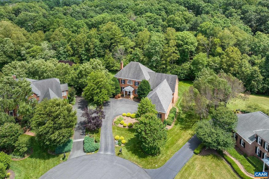 Stately five-bedroom, five-and-a-half-bath, renovated brick home tucked into a quiet Glenmore cul-de-sac, offering timeless elegance and modern luxury. A grand curved staircase welcomes you at the entry, flanked by a formal living room and a reimagined dining room with custom wet bar. The heart of the home is a beautifully renovated kitchen and family room, thoughtfully designed for both everyday living and entertaining. The chef?s kitchen opens to a new screened porch and grilling station (which conveys), overlooking a private backyard with a tranquil stream. The main level primary suite includes a serene sitting area, spa-like bathroom, and updated closets with generous storage. Upstairs offers three spacious bedrooms with en suite baths, a designated home gym, and a stylish new office. The walkout terrace level features a large rec space, full guest suite, and access to a new paver patio surrounded by wooded privacy. A three-car garage with epoxy floors leads into a newly added mudroom with custom built-ins. Purchase includes eligibility for a 50% discount on initiation to The Club at Glenmore.,Quartz Counter,White Cabinets,Fireplace in Family Room