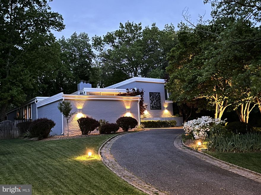 OFFER SUBMISSION DEADLINE MONDAY APRIL 15TH 6PM.  Nestled in the Potomac Village Community, this contemporary residence welcomes you with its elegantly mature landscaping, strategically placed uplighting and an inviting half-circle driveway that creates an impressive prelude to the architectural marvel that lies beyond. As you approach, the home's cool contemporary vibe immediately captivates, promising a blend of modern luxury and serene living spaces. Make your way up the brick paved entrance into the sun filled foyer that welcomes you with a feature pebble wall, high ceilings, oak hardwood floors, recessed lighting, and open to the sunken living room. In the living room you can enjoy the light from the transom windows, cozy up on the built-in couch next to the gas fireplace. A powder room is conveniently located near the main entrance and office. The office features large built-in cabinetry with a surprise walk-in closet featuring shoe storage and wooden shelving, giving this office the alternate use of a fifth bedroom!  The kitchen features new LVP flooring, updated backsplash and quartz countertops, built-in desk area, large center island with gas cooking, wine fridge, dual oven, built in bench seating, brick wall feature, and large walk-in pantry featuring main level laundry. The kitchen flows directly into the dining room with sconce lighting, chair rail, modern farmhouse chandelier, feature brick wall, serene views of the backyard. The main family room creates the perfect space for entertaining as it has direct access to the back yard, a gas fireplace, hardwood floors, sky lights and wooden beams. Enjoy full main level living as the first primary suite is located on the main level with built-in storage, a modern feature wall, and updated ensuite with a new dual vanity with Carrera Marble countertops, floor to ceiling tiled shower with motion sensor backlighting, jetted tub and full access to the walk in closets with custom organizers built-in. Upstairs you will find a second primary suite with a neutral bathroom, and views overlooking the pool. Additionally are bedrooms four and five with casement windows, crown molding and access to the third updated full bathroom. The basement completes the interior living spaces offering the perfect space to lounge, create, or work out! Featuring built in bookshelves and entertainment unit, a newly installed full bathroom, back recreation space with additional book cases and glass french doors to a the perfect room for a gym with a mirrored wall. The home also features a two-car attached garage, and ecobee thermostat. Feel like you are on vacation, as you will never want to leave the backyard! Enjoy dinners on the trek decking with solar lighting and full deck retractable shade. The mature landscaping, stone retaining wall, and privacy fence, make it feel completely serene as you soak in the 6ft deep salt water pool with a custom emblem highlighted in the center of the pool. Don’t miss the second outdoor powder room right off of the pool area, perfect for guest use. Enjoy all this home has to offer plus the prime location, situated less than a mile from the vibrant Potomac Village. Here, an array of shops, dining establishments, and social hubs await your exploration. The property also offers unparalleled convenience for commuters, with easy access to major thoroughfares such as the Beltway, River Road, and Falls Road. Nature enthusiasts will revel in the proximity to expansive national parks including Great Falls Park, the C&O Canal National Historical Park and Trail, and the scenic Potomac River. For golf aficionados, premier courses like TPC at Avenel and Congressional Country Club are just around the corner.