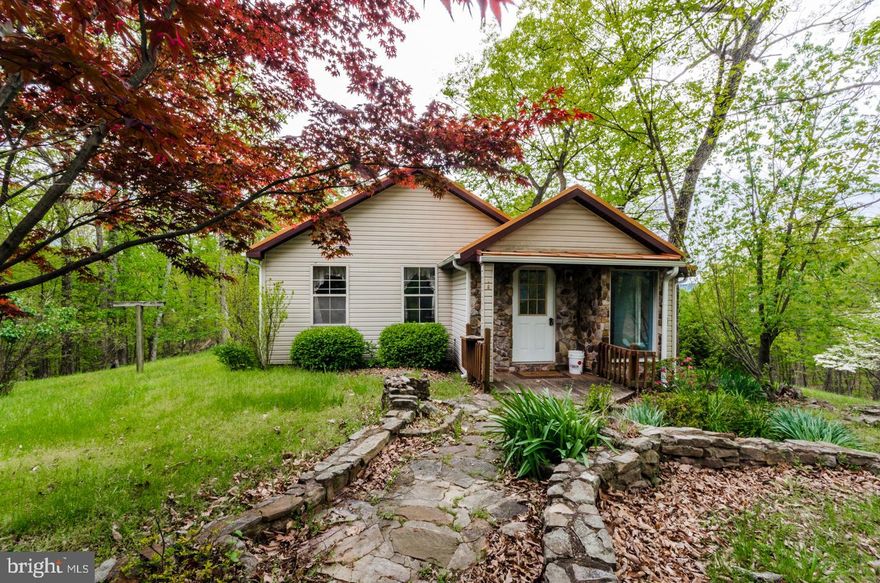 5.57 unrestricted acres with a small chalet home. Native stone features inside and out give this home a unique feeling.  Master bedroom with wood burning fireplace, tongue and groove ceilings, wood floors, and den with woodstove. Winter views of the mountains, a small wet weather pond with outdoor fireplace. Private and secluded in mostly wooded setting. New Seamless Metal Roof and gutters in 2019