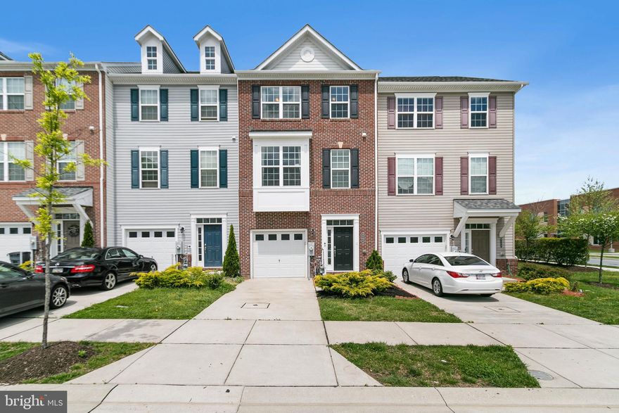 Beautiful 3-Level Oakland II model by Beazer Homes. Nested in Ballard Green community, this spacious 3- bedroom, 2-full bath, 2-half bath brick-front features 2,160 sf of total space, and a 1-car garage with epoxy finishing and storage rack. The home welcomes you to an open foyer that leads to a spacious recreational area with projector pre-wiring, extra closet space, half bath, and access to 20’ x 20’ backyard. The bay window in the main level allows ample natural light to come into the home, and is complimented by recessed lighting, a powder room, and an open-concept floor plan that oversees kitchen and dining room. The gourmet kitchen showcases 5” hardwood plank flooring, upgraded white cabinetry with matching tile backsplash, granite countertops with island, whirlpool stainless steel appliances, 5-burner stove, 2-door refrigerator, and 5.1 channel in wall wiring for speakers. Dining room walks out to 18x10 composite deck. Upper level includes Master suite with dual closets. Master bath features dual vanity, soaking tub, and standing shower. Two additional generous sized bedrooms, a hallway bath, and laundry room are also featured in the upper level. The Home sits in front of a common grassed area, and is within walking distance from Club House. Additional overflow parking is available within community. Adjacent to Lyons Mill Elementary School. Amenities include a pool, a community center with gym, a tot lot, and picnic area. Convenient to 795 & Metro. Nearby shopping incl. Costco, BJ's, & Wegmans.