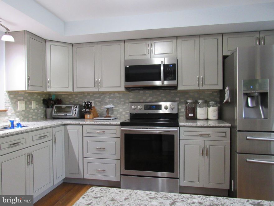 Welcome to 7961 Parkland Place located in Frederick, Maryland, in the heart of the Waterside Community. This is a well maintained three level colonial brick townhouse with 1,904 square feet of living space, three bedrooms, and four bathrooms. As you walk into the townhouse, you are welcomed with hardwood stairs and flooring. The main level of the townhouse includes hardwood floors in the kitchen, dining room, and living room. The kitchen boasts Quartz counters with stainless steel appliances 5 years young that include a dishwasher, electric glass top stove, a refrigerator and freezer with a built-in ice maker, and a built-in microwave purchased 7/2023. The dining room opens up to the living room area where you can walk straight to the deck through a storm and screened door. As you make your way towards the entrance to the upper level, you are greeted with a bathroom with ceramic tiles and a single sink cabinet with freshly painted walls. The hardwood staircase leading to the upper-level brings you to the three bedrooms with wall-to-wall carpeting. The upper level includes the primary bedroom and bathroom, two additional bedrooms and a hall bathroom.The three bedrooms each include ceiling fans. The primary bathroom has a single sink quartz counter cabinet with ceramic tile flooring and a ceramic tile shower with a skylight for natural sunlight. The hall bathroom includes a single sink granite counter cabinet with ceramic tile flooring and a tub with ceramic tile walls and a sliding glass door. The laundry is conveniently located in the hallway between the bedrooms. Both washer and dryer are front loading purchased 9/2023 and 9/2022. Taking the hardwood staircase to the lower level, you are greeted with beautiful ceramic tile flooring. The lower level includes a half bathroom with a granite counter cabinet and an office space with a walkout sliding glass door. One car garage is accessible from the lower level. The location of the townhouse has nearby access to Rt 15 and Rt 70 and is within minutes of Wormans Mills, nearby shops, restaurants, a community park with playground area, a community pool, tennis court, walking paths near Monocacy River, and seasonal community events. NO City Taxes.